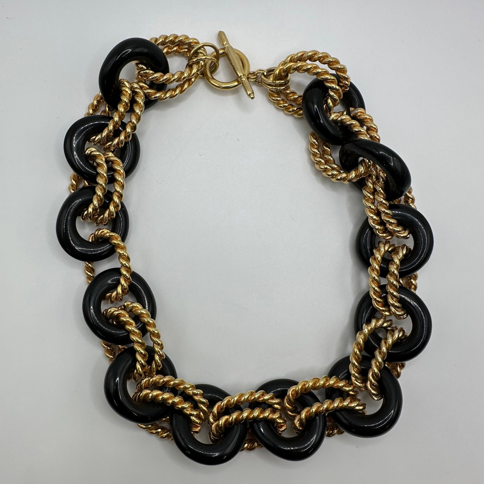 Kenneth Jay Lane Black Resin Gold Tone Chain Link Necklace KJL: This is a Kenneth Jay Lane (KJL) Black Double Gold Twist Necklace. It is a chunky, bold fashion style featuring a popular design style of the 90s. The necklace is composed of alternating large, black 