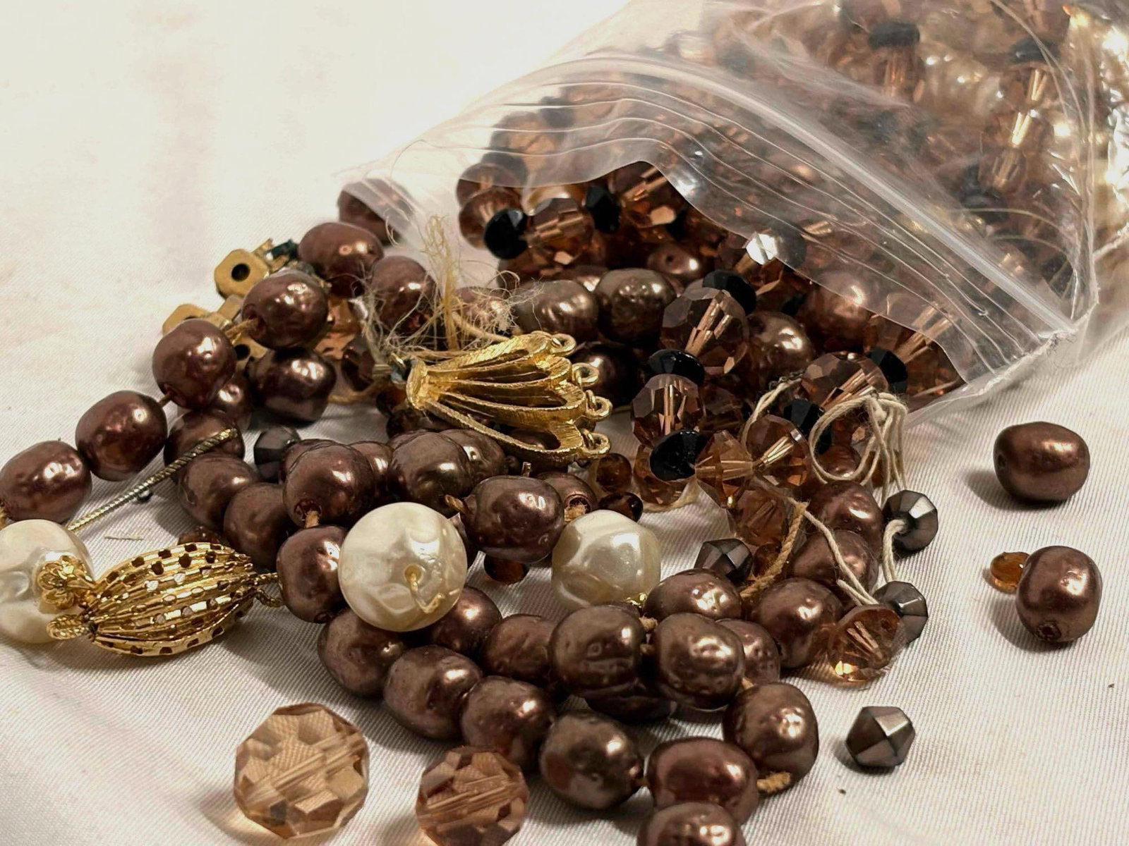 14 Plus Ounces of Bronze Toned Charms, Beads, Broken Costume Jewelry and More: This lot contains over 14 ounces of misc pre-owned broken costume jewelry, loose beads, charms, and more. This goodie bag is intended for crafters and artists, sorted by complimentary items and