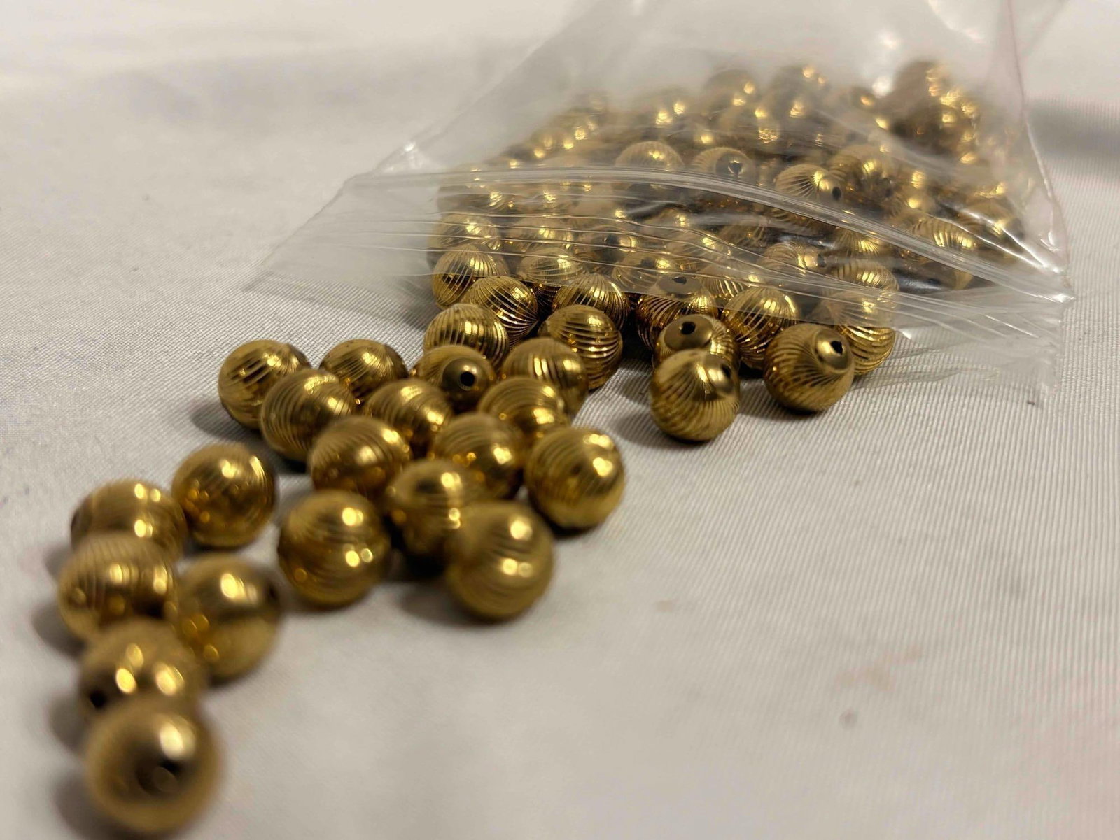 7 Plus Ounces of Gold Toned Textured Costume Jewelry Beads: This lot contains over 7 ounces of Gold-toned beads. This goodie bag is intended for crafters and artists. APPROX WEIGHT: 7.5 OZ
