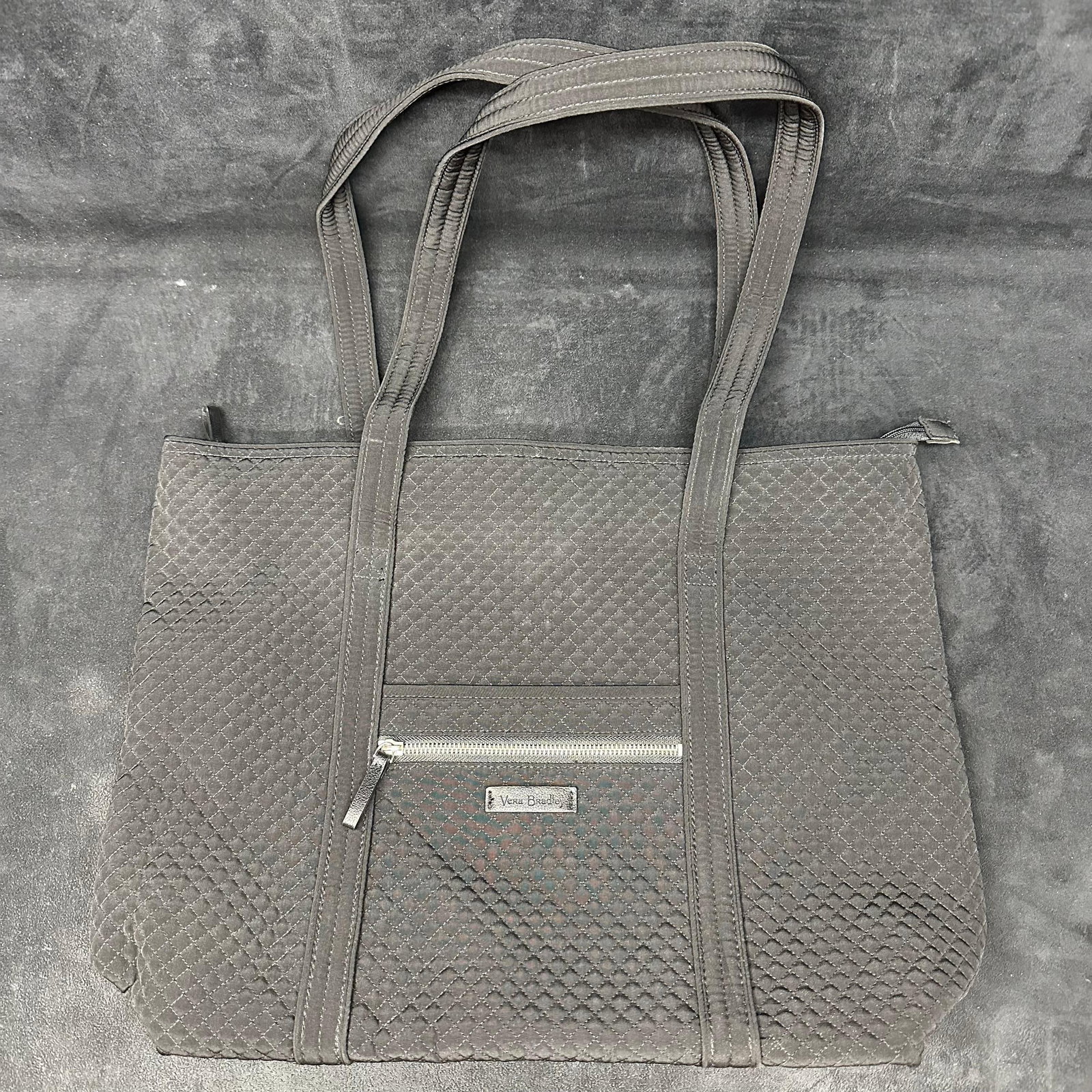 Vera Bradley Quilted Black Tote Bag with Zipper Closure: Vera Bradley quilted tote bag in solid black fabric. Features double shoulder straps, top zipper closure, exterior zip pocket, and patterned fabric interior with multiple slip pockets. This item is in