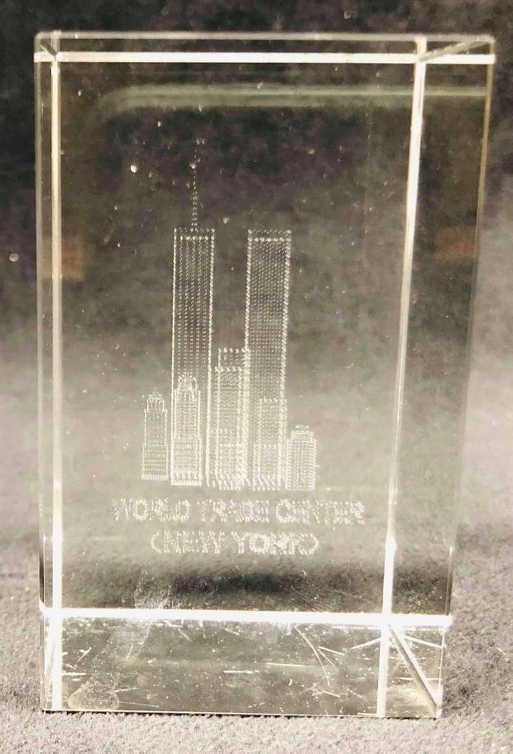 Glass Paperweight Etching Of The World Trade Center (New York): This lot contains a Glass Paperweight Etching of The World Trade Center (New York). It is approx 2" x 2" x 3 1/4" and it weighs about 1lb. Overall the Glass Art Etching is in good used condition with 