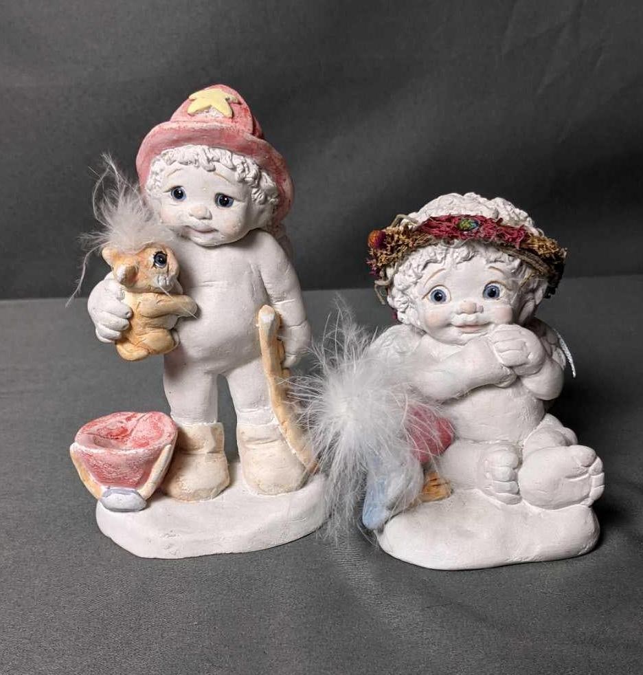 Two Dreamsicles Figurines (1) "Burin Love" (2) "Have a Heart": (1) "Burin love" Fireman Baby with rabbit. Wear on the bottom and dust discoloration. 5 1/2" x 3 1/4" (2) "Have a Heart" Baby Angel receiving heart from a bird. Goo