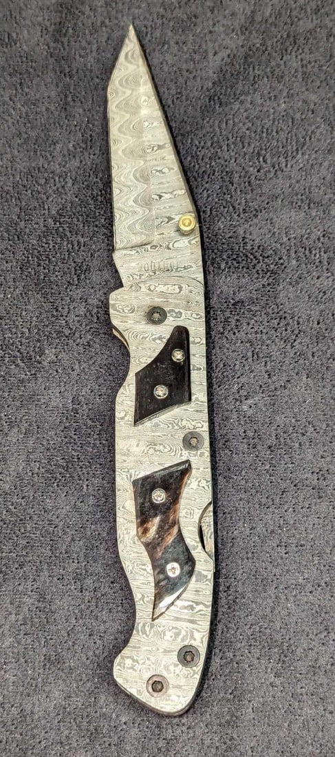 Damascus Steel Fold Up Black Bone Handle Knife Retired A: Damascus Steel Fold Up Black Bone Handle Knife Retired A. Here is a fold-up knife made of imported Damascus steel with a black natural bone handle. These were made in very limited batches by a sm