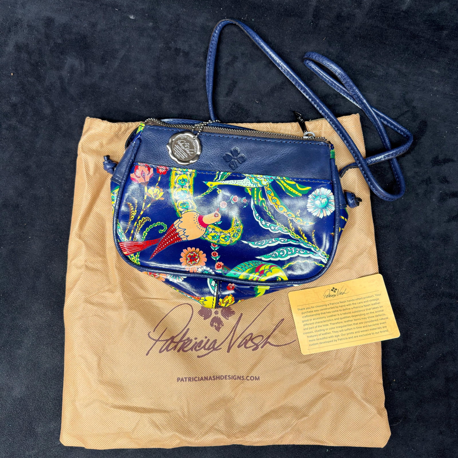 Patricia Nash Blue Leather and Bird Tropical Print Crossbody Shoulder Small Bag: Patricia Nash genuine leather crossbody handbag featuring a vibrant blue multicolor bird and floral print with an adjustable shoulder strap. The bag includes a zip-top closure, suede-lined interior wi
