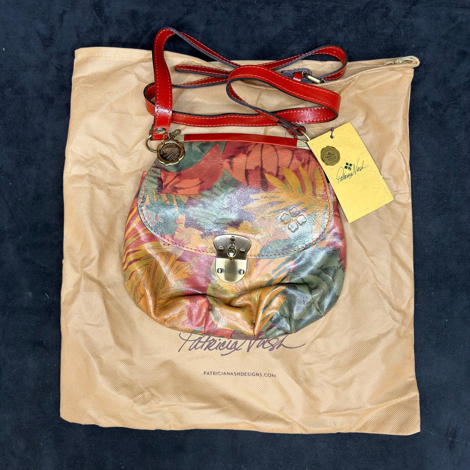 Patricia Nash Tropical Floral Leather Crossbody Shoulder Bag: Patricia Nash genuine leather crossbody handbag featuring a multicolor tropical floral print, adjustable leather shoulder strap, flap with turn-lock closure, brass-tone hardware, and suede-lined flap.