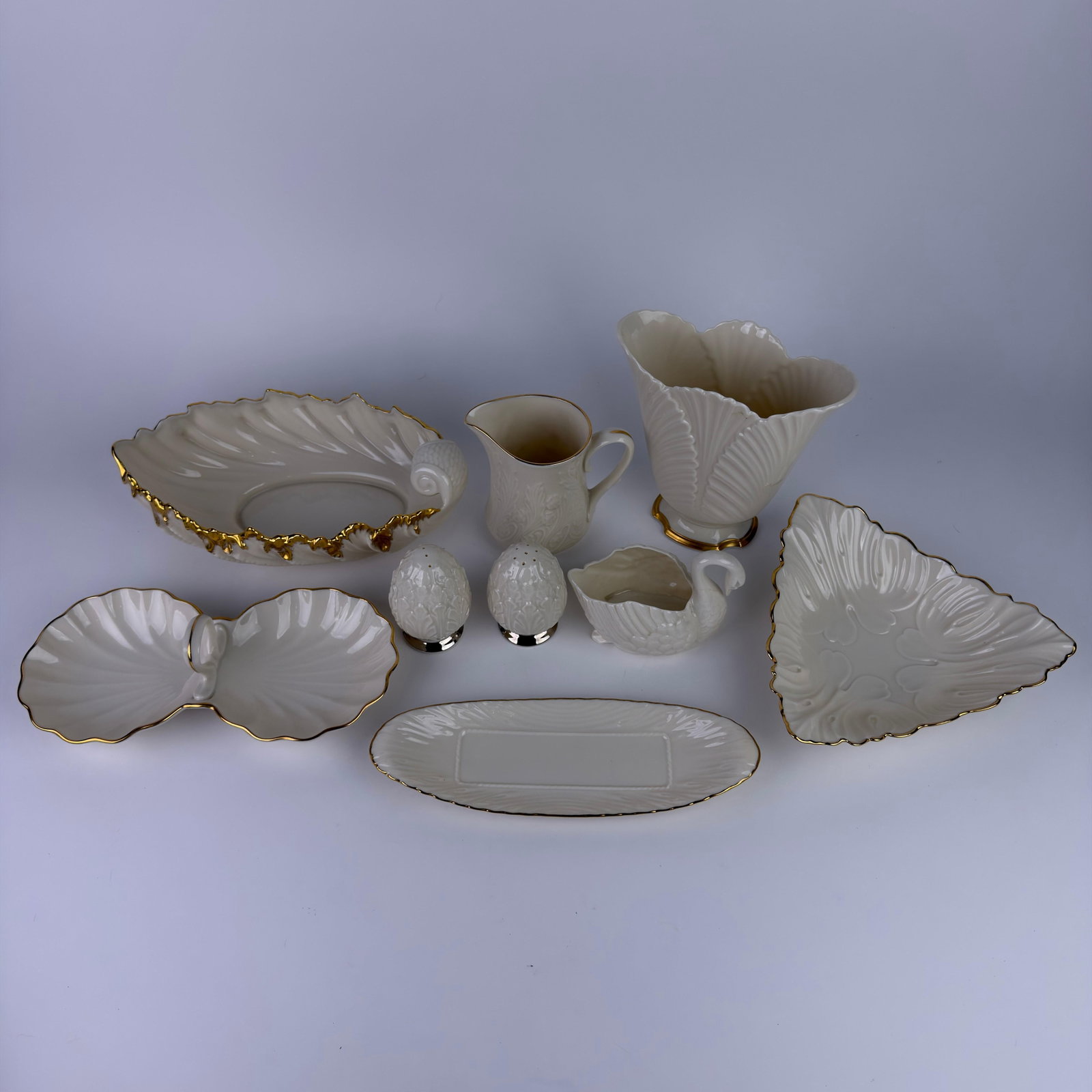 Lenox Ivory Tone Cream Colored Porcelain Decorative Serveware Table Accessories 9 Pc Swan: Group of nine Lenox ivory- and cream-colored porcelain decorative table accessories with 24K gold and platinum trim. Lot includes a shell-form centerpiece bowl with a gilt accent, a double-shell relis