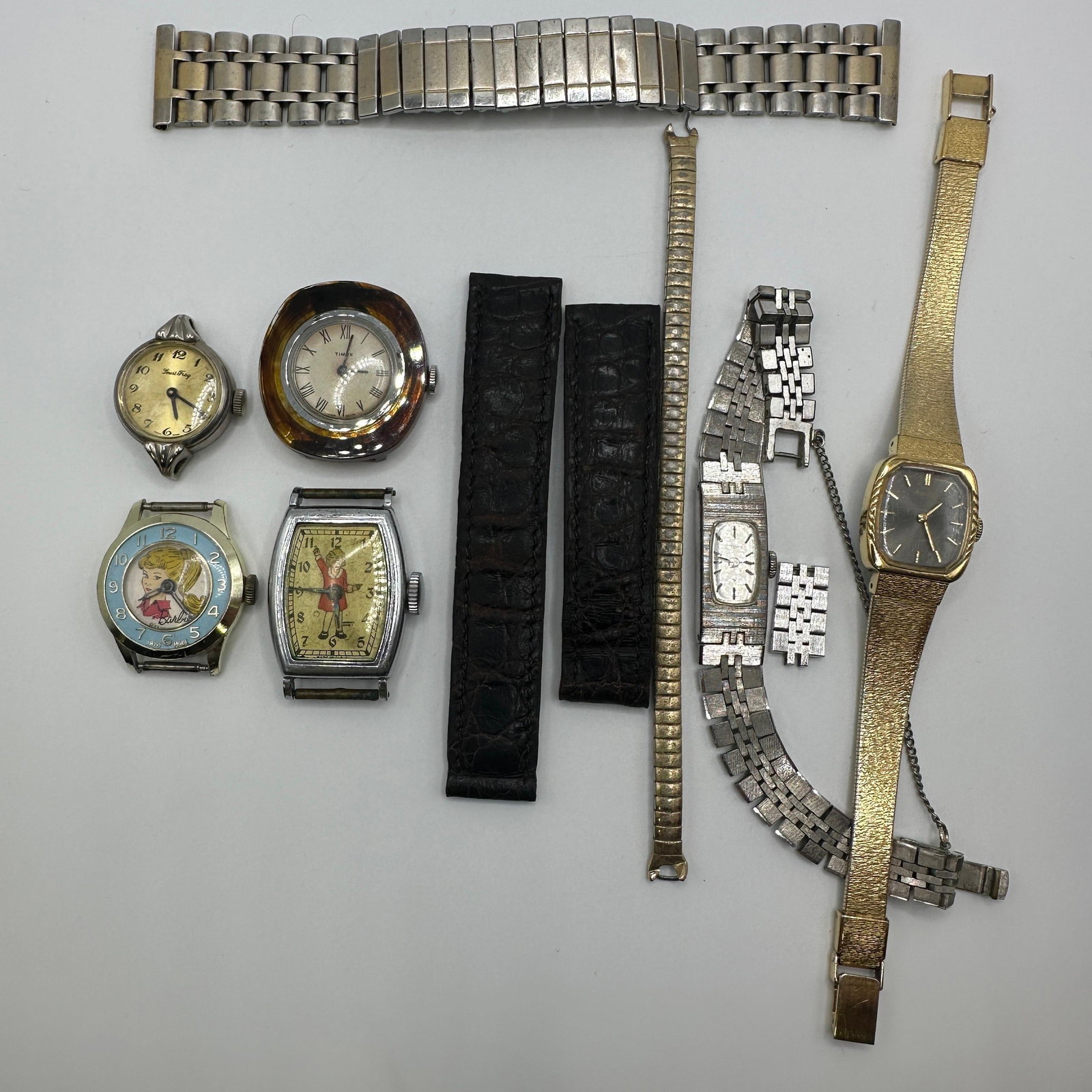 Vintage Wristwatch Parts Lot Including Seiko Timex Barbie and Expansion Leather Cartier Bands: Mixed vintage wristwatch and watch parts lot including Seiko ladies wristwatch, Timex watch head, Louis Frey watch, Barbie character watch, novelty figural dial watch Little Orphan Annie, expansion wa
