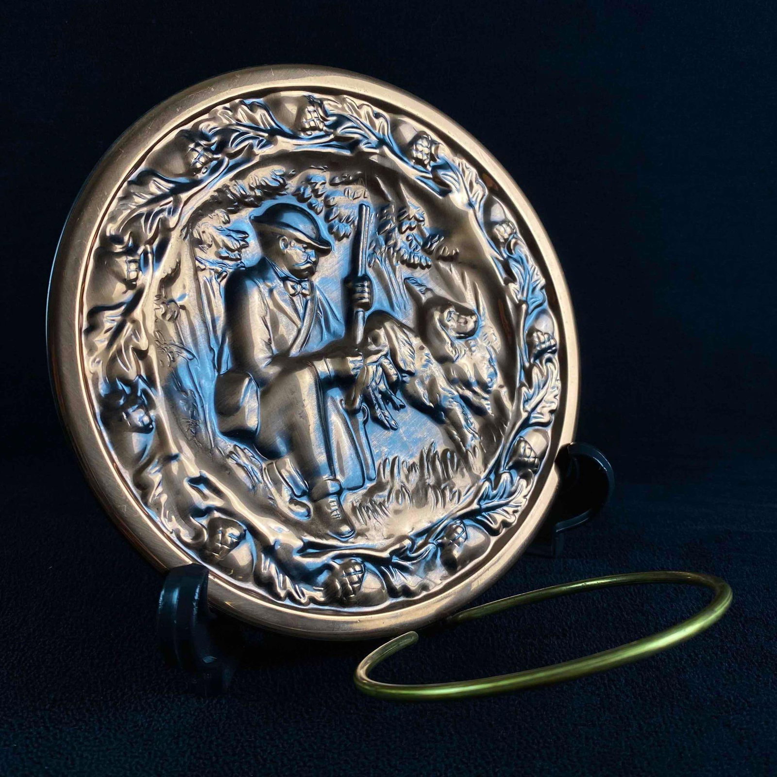 6.5" Decorative Copper Plate/Candleholder: 6.5" Decorative Copper Plate/Candleholder Decorative copper plate with relief design and brass loop for candleholder. Shows a hunter with his dog. In good condition with no known damage. Approxima