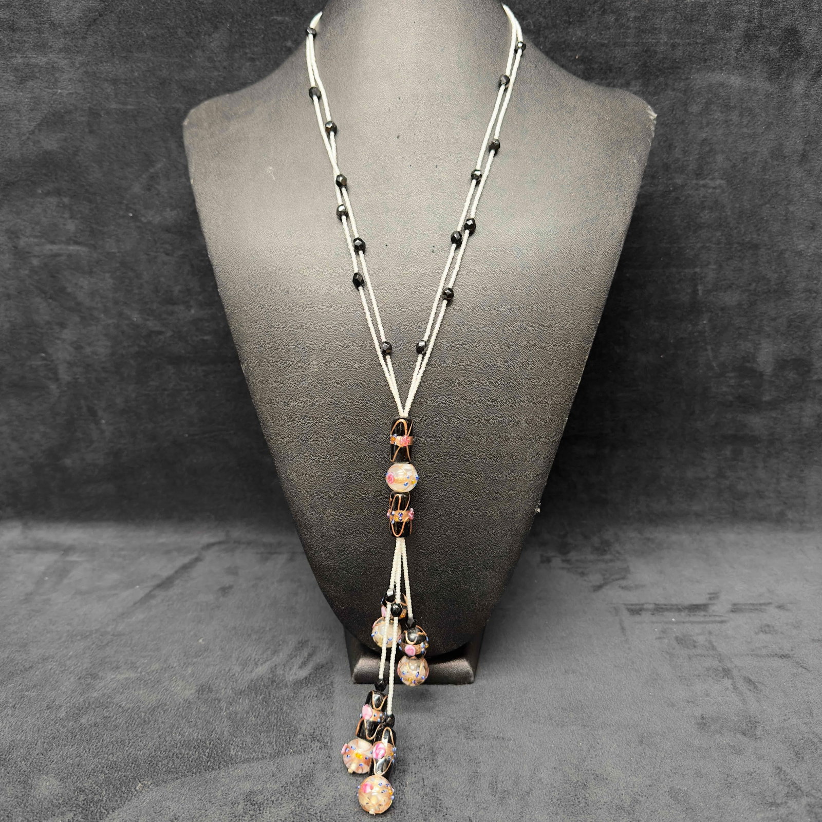 Murano Venetian Lamp Work Art Glass Clear and Black Floral Beaded Pendant Necklace H25: Murano Venetian Lamp Work Art Glass Clear and Black Floral Beaded Pendant Necklace H25. Necklace with clear and black colored glass beads with beautiful designs on each. The necklace features copper
