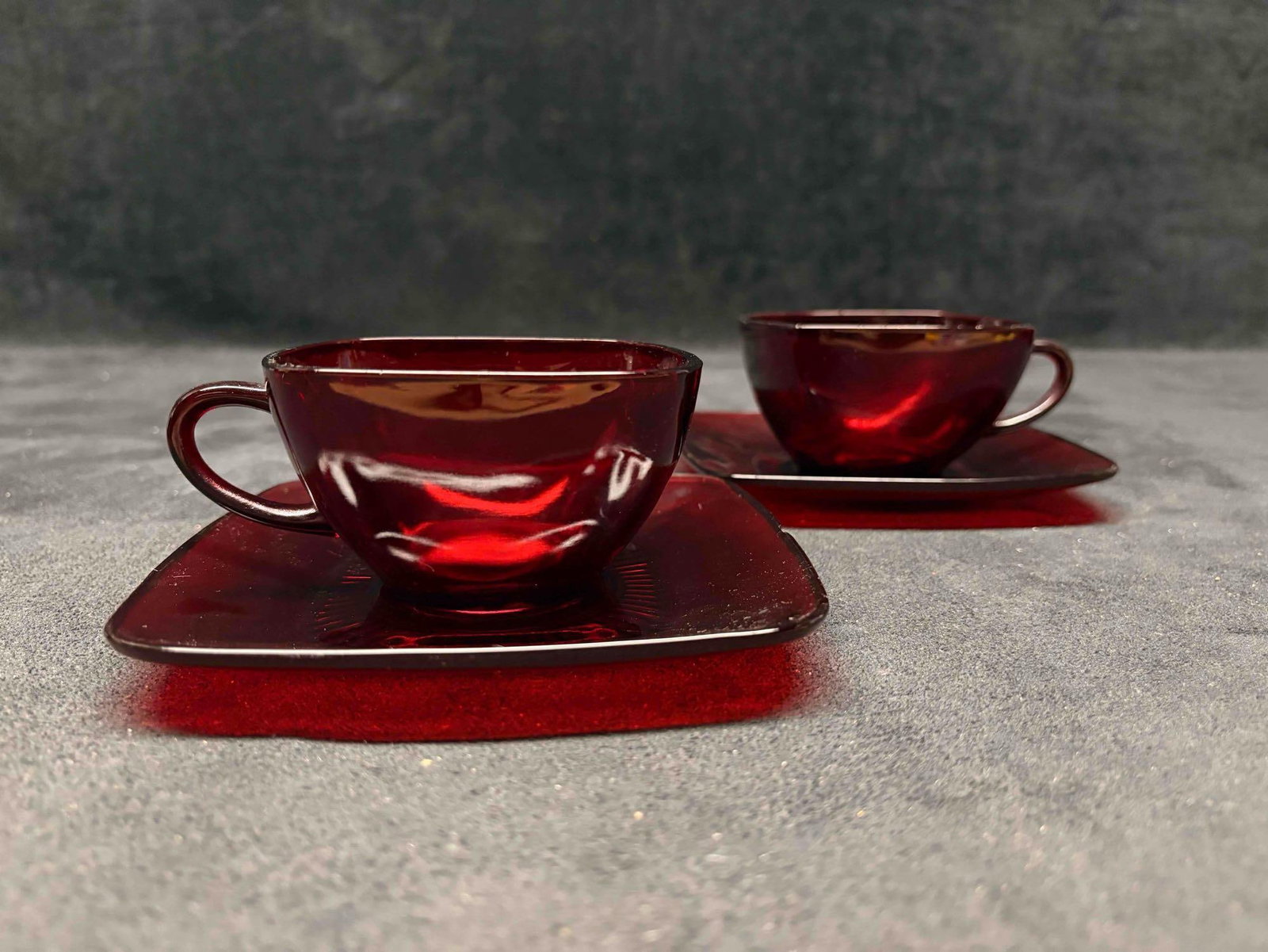 Set of Two Vintage Fire King Charm Teacups and Saucers by Anchor Hooking: This lot includes a set of two (2) Fire-King Charm Teacups and Saucers from Anchor Hocking; produced primarily between the 1940s and 1960s. this mid-century collection is characterized by its