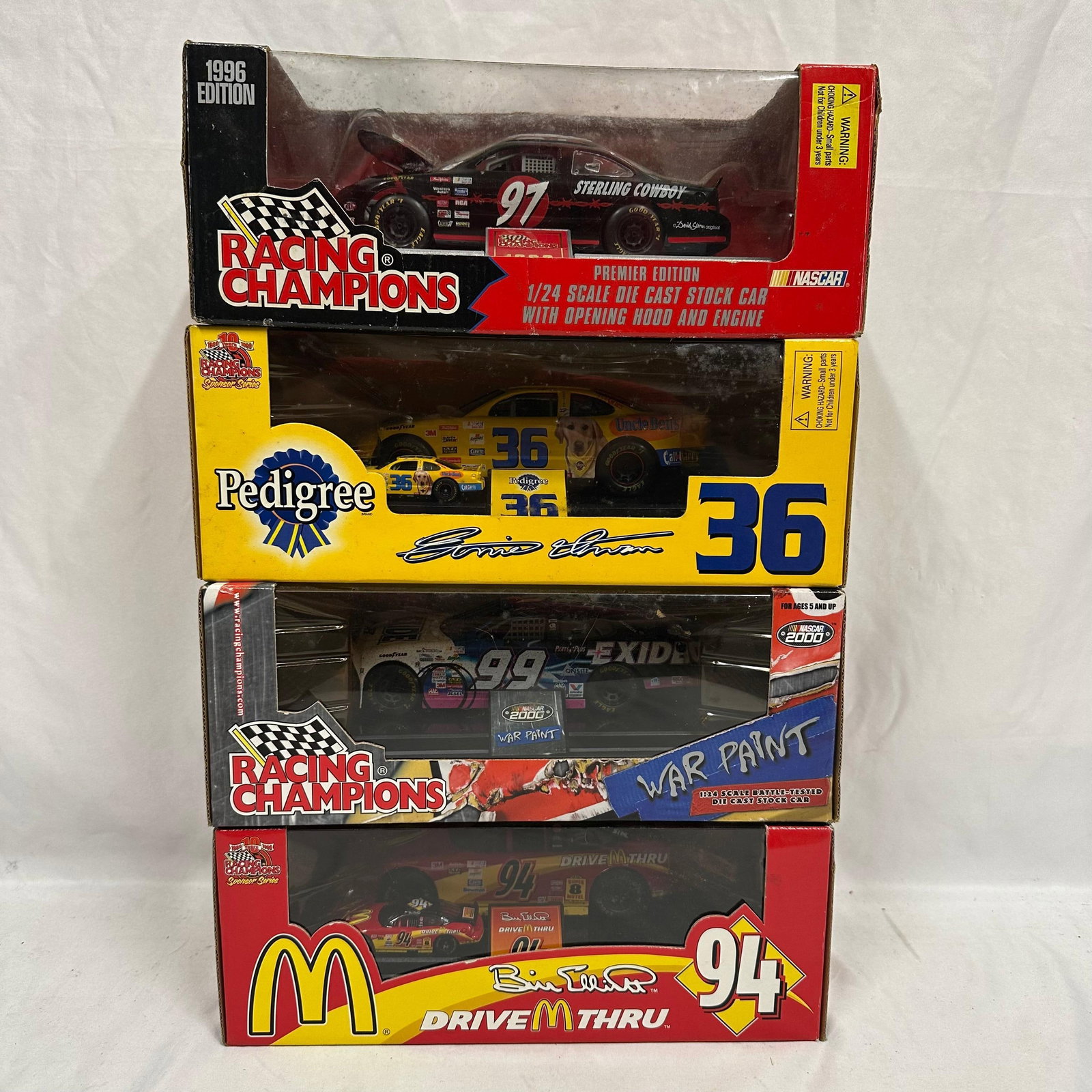 Lot of Four Racing Champions 1:24 NASCAR Die-Cast Cars McDonald's Pedigree: Collection of four boxed Racing Champions NASCAR 1:24 scale die-cast stock cars, each featuring detailed paint schemes and authentic sponsor graphics. Includes: 1996 Sterling Marlin #97 Sterling Cowbo