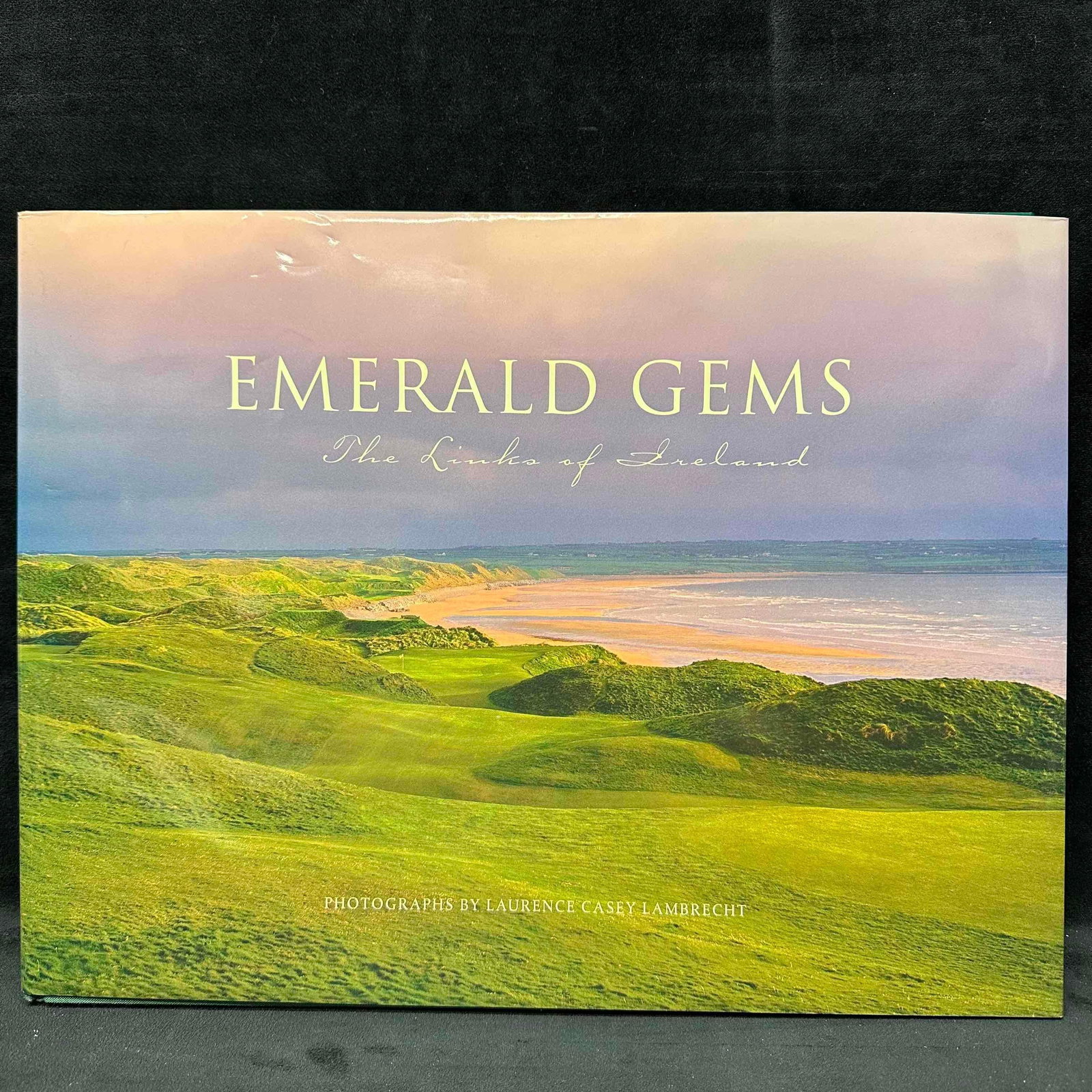 Emerald Gems The Links of Ireland Laurence Casey Lambrecht Golf Photography Hardbound Book: Beautiful large-format photography book Emerald Gems: The Links of Ireland with photographs by acclaimed golf photographer Laurence Casey Lambrecht. This coffee table book captures Ireland’s leg