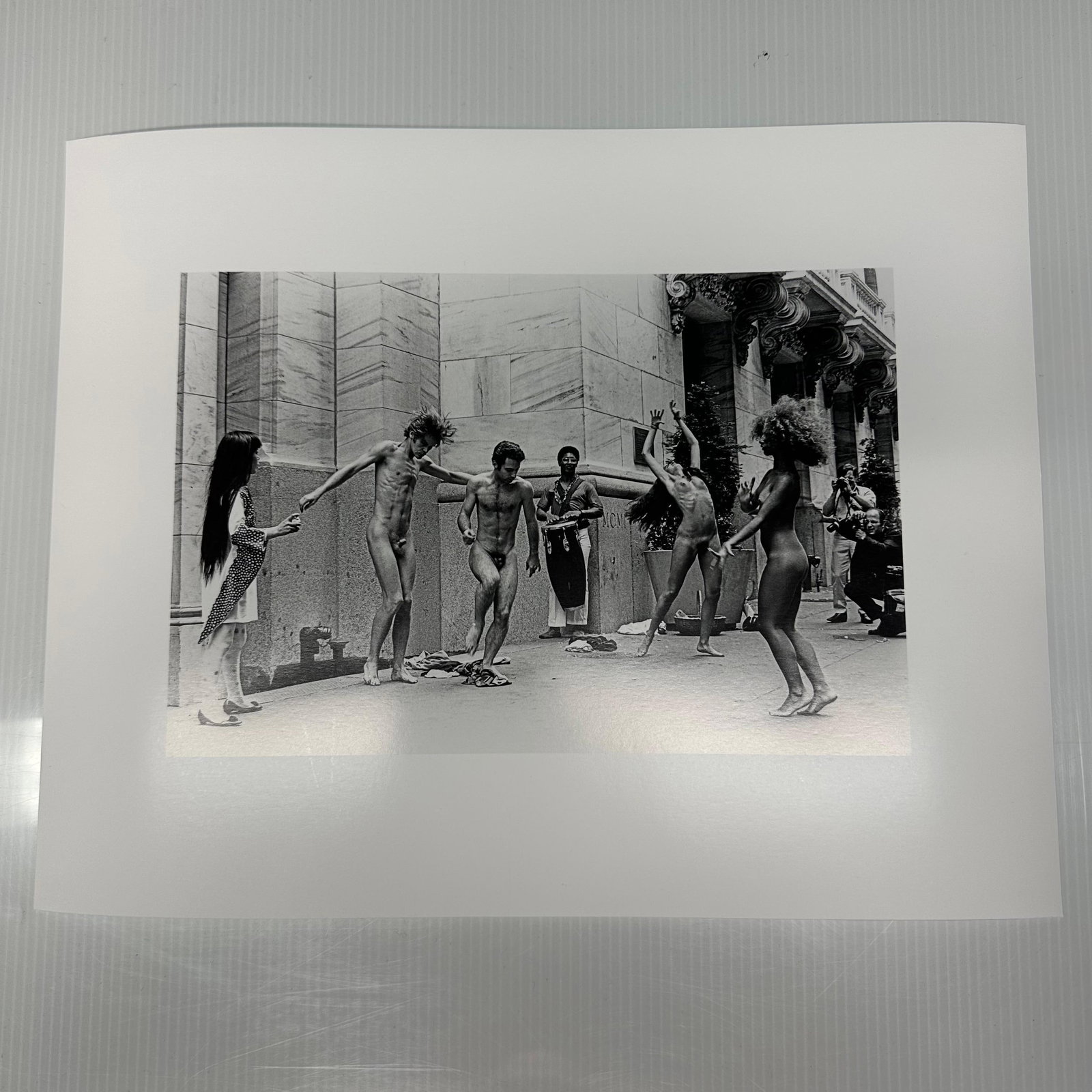 Yayoi Kusama Body Festival Black and White Photo Print: Black and white photographic print depicting Yayoi Kusama’s nude performance happening (Body Festival) outside a New York City building, circa late 1960s. The image shows dancers and onlookers d