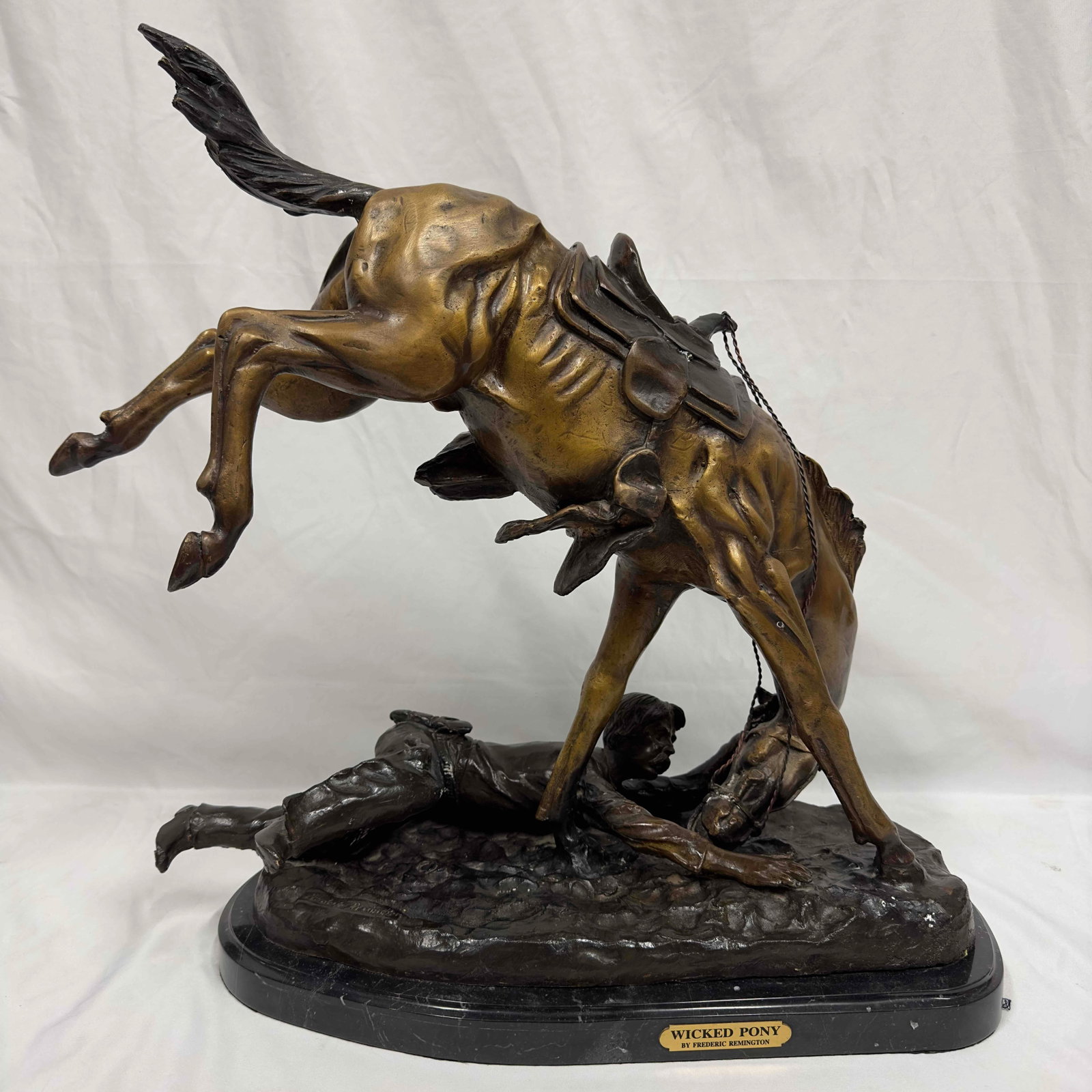Wicked Pony By Frederic Remington Hand Made Real Bronze Art Sculpture Large Jumbo Figure: This dynamic large bronze sculpture depicts a cowboy thrown from his horse. This bronze statue has a black marble base and Frederic Remington etched into the bottom bronze base portion. Statue is