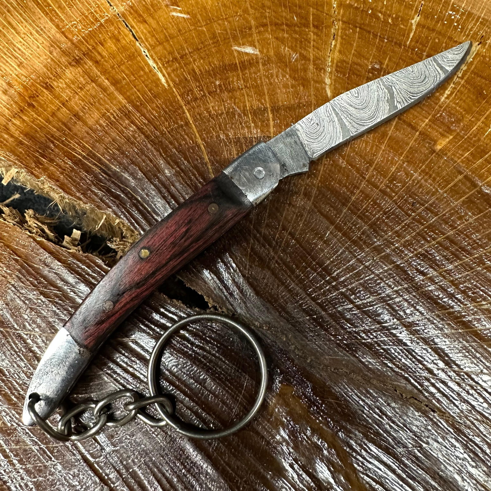 MHS Cutlery Keychain Steel Folding Blade Pocket Knife R53: Small folding-blade pocket knife featuring a steel blade and a compact epoxy-resin/wood handle secured with brass pins. Includes an attached metal key ring for easy carry. Good like-new condition with