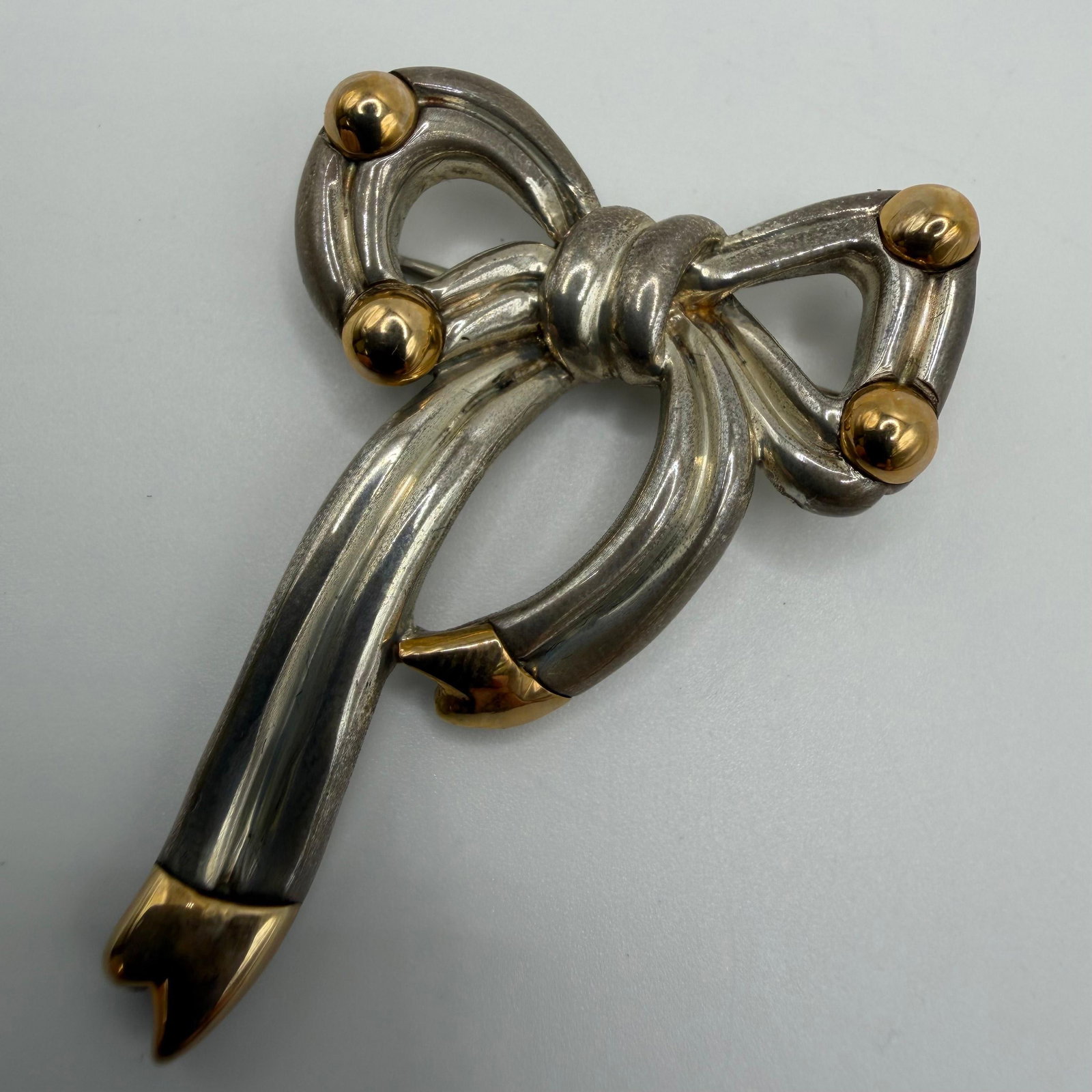 Remy Rotenier Sterling Silver and 14K Gold Bow Brooch: This item is in good pre-owned, previously used/displayed condition with noticeable light wear and surface scratches. Please reference all photos for full details. This piece of jewelry has been caref