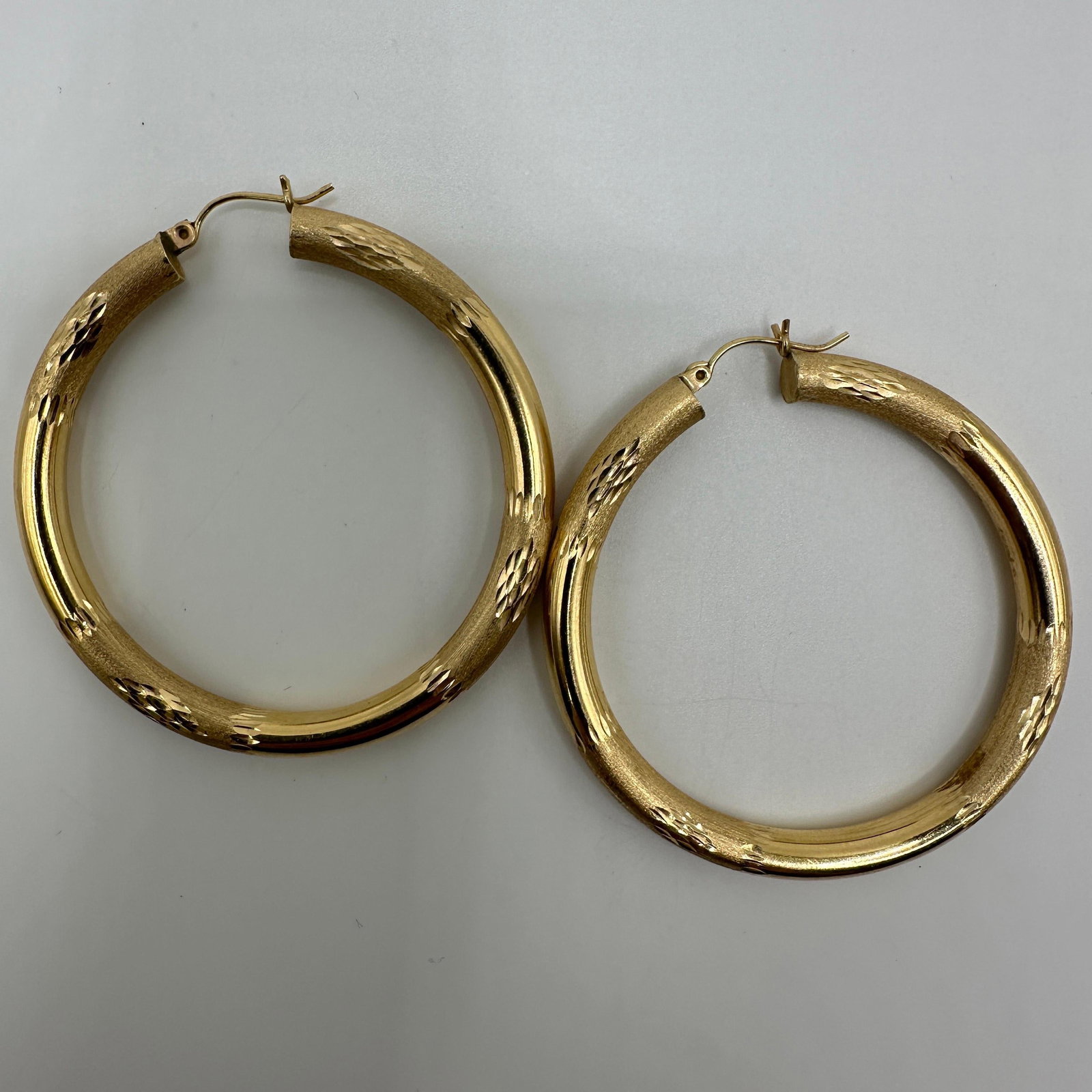 Etched Textured Hoop Earrings 14K Yellow Gold A20: This item is in good pre-owned condition, previously used/displayed, with noticeable light wear and surface scratches. Please reference all photos for full details. This piece of jewelry has been care