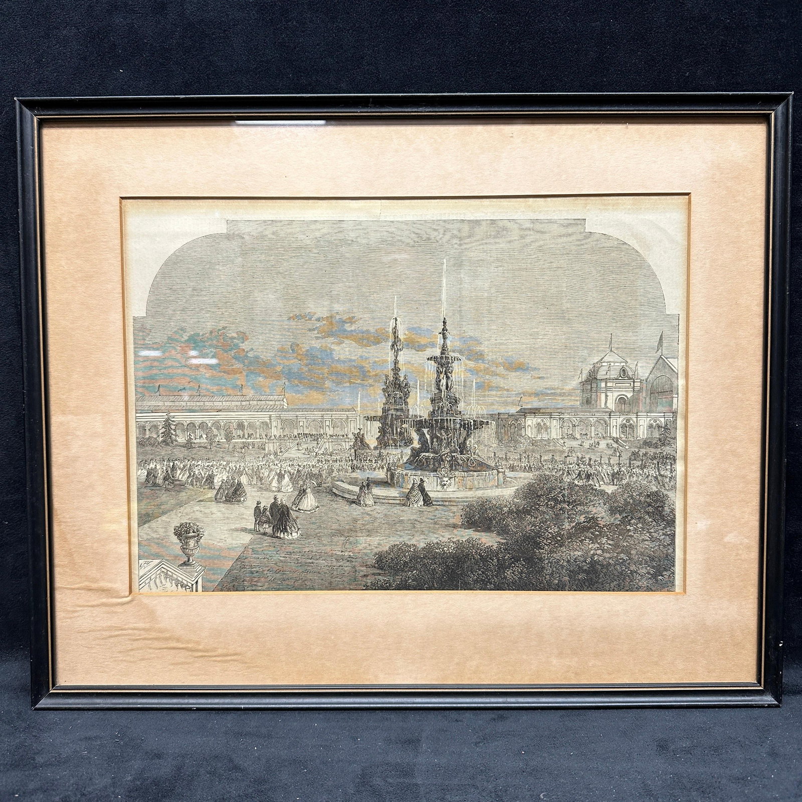 Victorian Exhibition Fountain Scene Framed Engraving Art Print: Black and white engraving depicting a large public exhibition garden scene with a central fountain, crowds in Victorian dress, and surrounding architectural buildings. Likely inspired by a 19th-centur