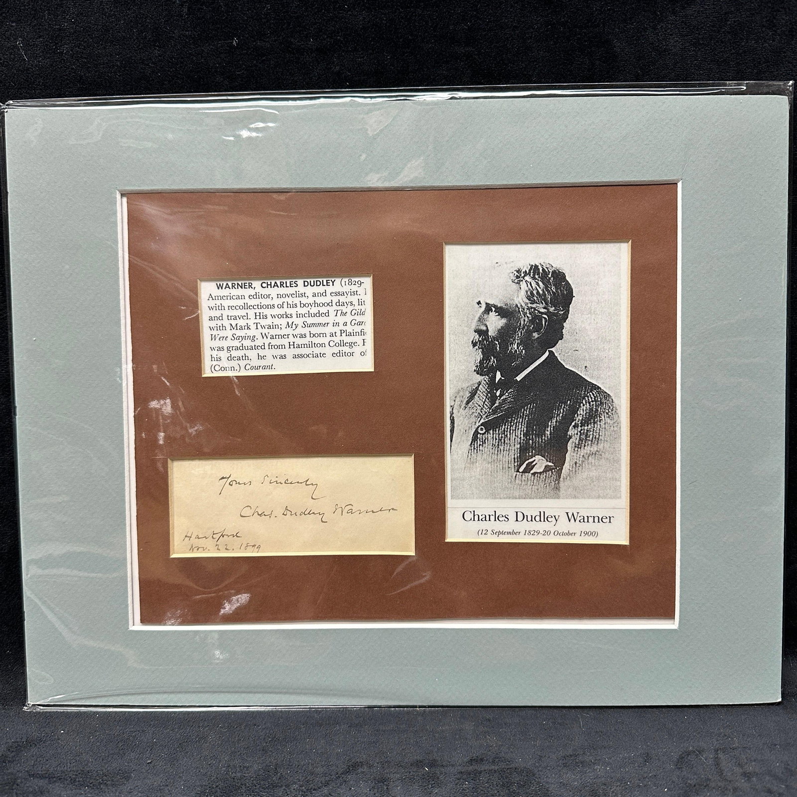 Charles Dudley Warner Signed Autograph Display With Portrait: Framed autograph display featuring a clipped handwritten signature of Charles Dudley Warner, dated Hartford, Nov 22, 1899. Includes printed biographical excerpt and portrait of the American editor, no