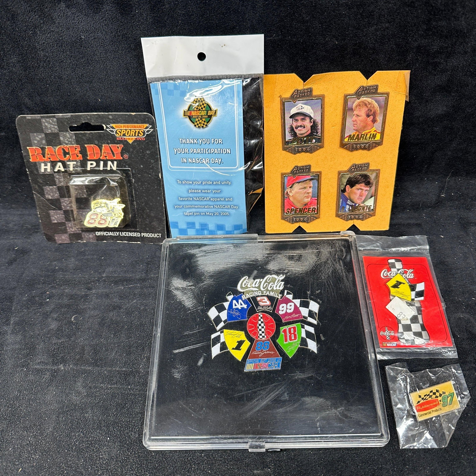 NASCAR Lapel Pin Collection Coca Cola Race Hat Pins: Fourteen pins total. Most items remain in original packaging with visible shelf wear, edge wear, creasing, and storage wear to packaging. Please reference all photos for full condition details. Size T