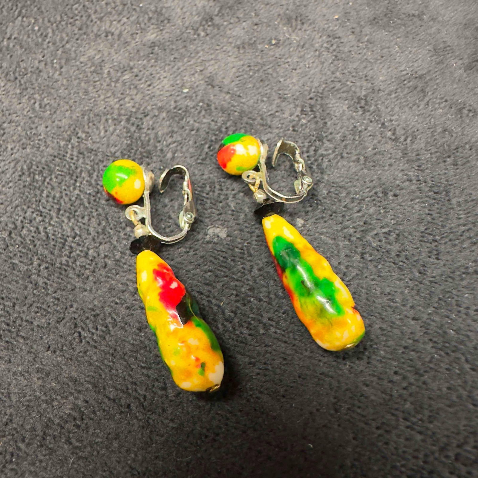 Hand Painted Ceramic Dangle Drop Earrings Red Yellow Green: Hand Painted Ceramic Dangle Drop Earrings Red Yellow Green. Earrings with ceramic beads with beautiful designs on each. The earrings feature red, yellow, and green colored accents. The earrings featur