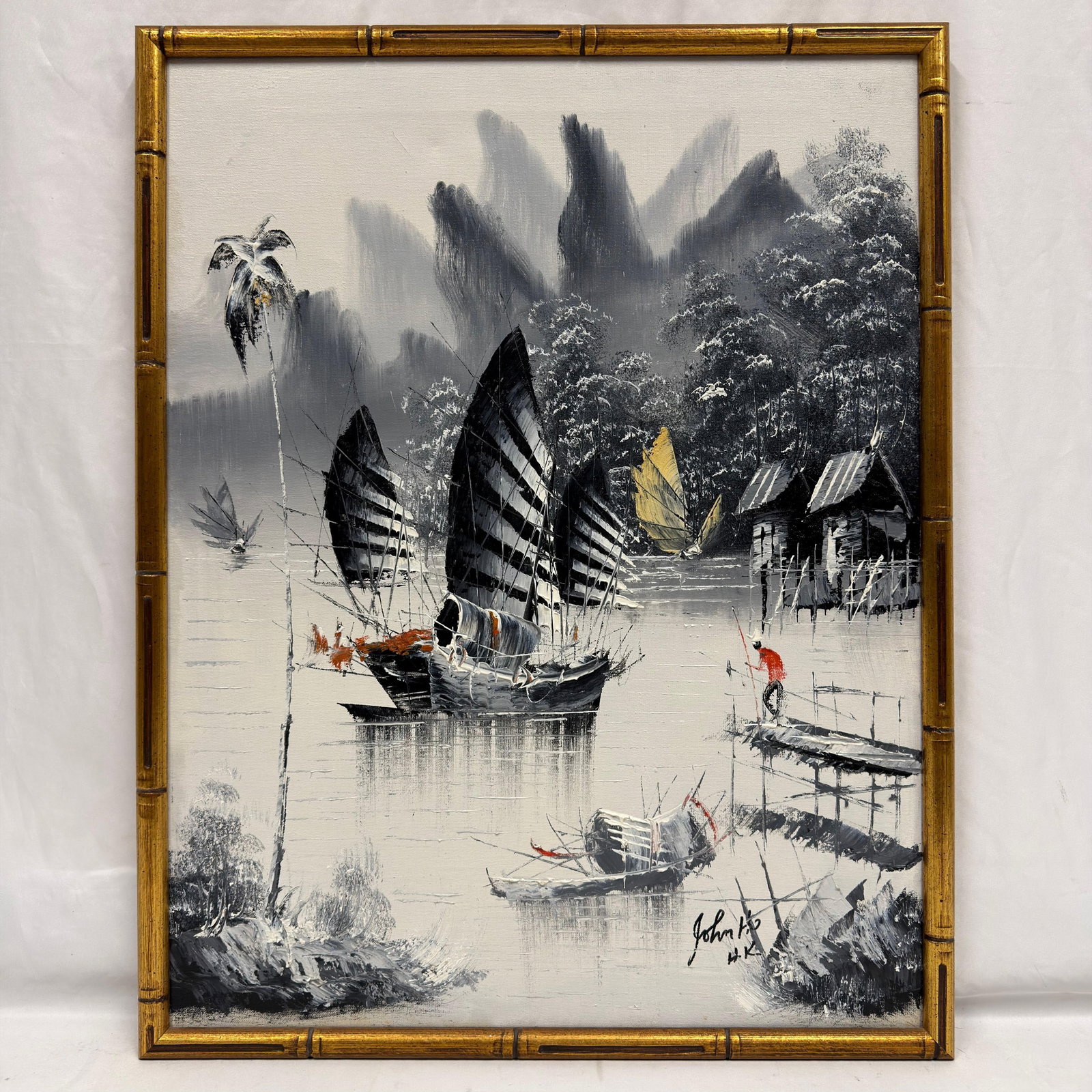 Signed John Ho HK Hong Kong Harbor Junk Boat Oil Painting Bamboo Style Frame: Vintage original oil painting on canvas depicting an Asian harbor landscape with traditional Chinese junk boats, waterfront dwellings, mountains, and figures. Executed primarily in black, white, and g