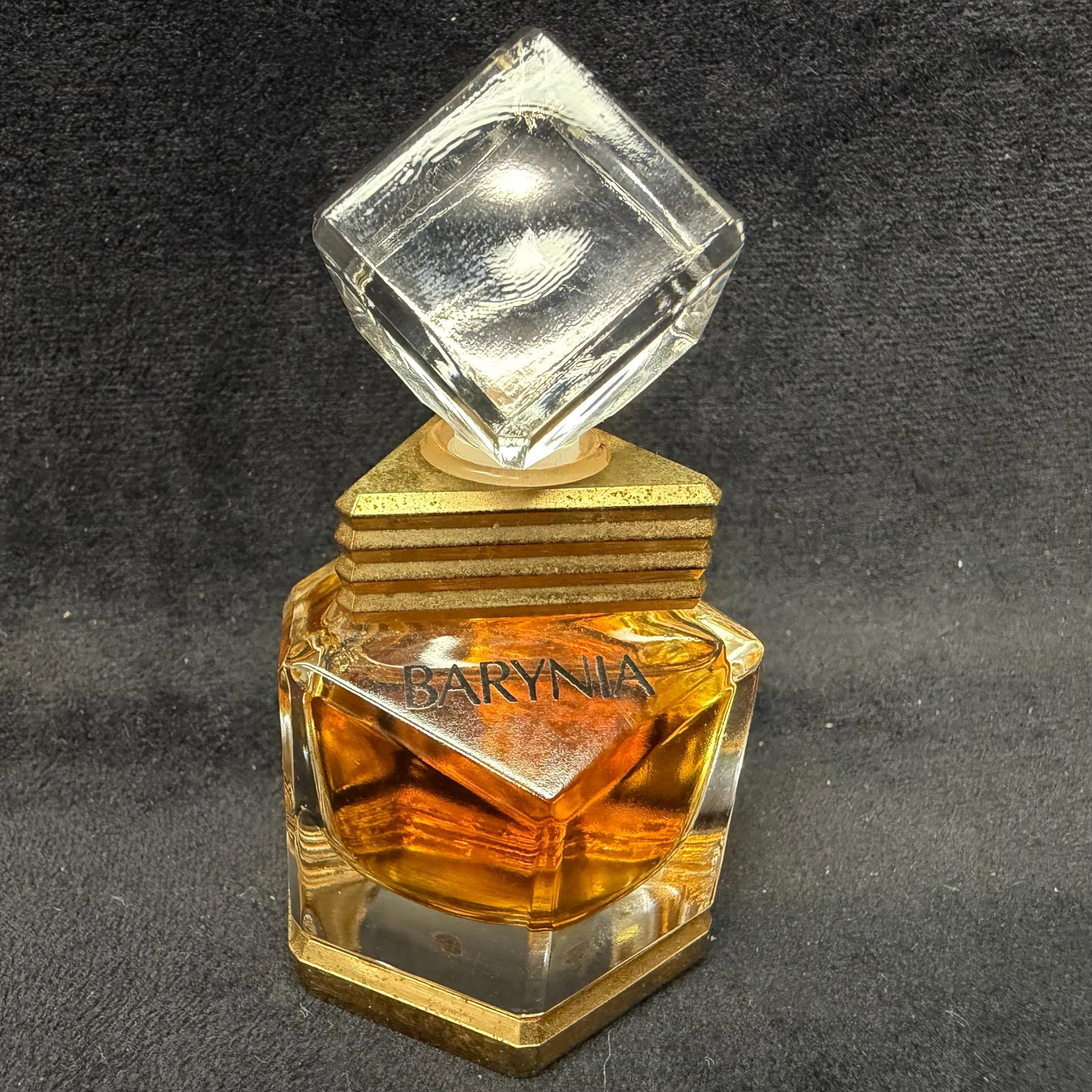 Helena Rubinstein Barynia Parfum Perfume Bottle Small: Barynia parfum by Helena Rubinstein, a discontinued fragrance introduced in the 1980s. Presented in its distinctive heavy faceted glass bottle with a geometric clear stopper and gold-tone architectura