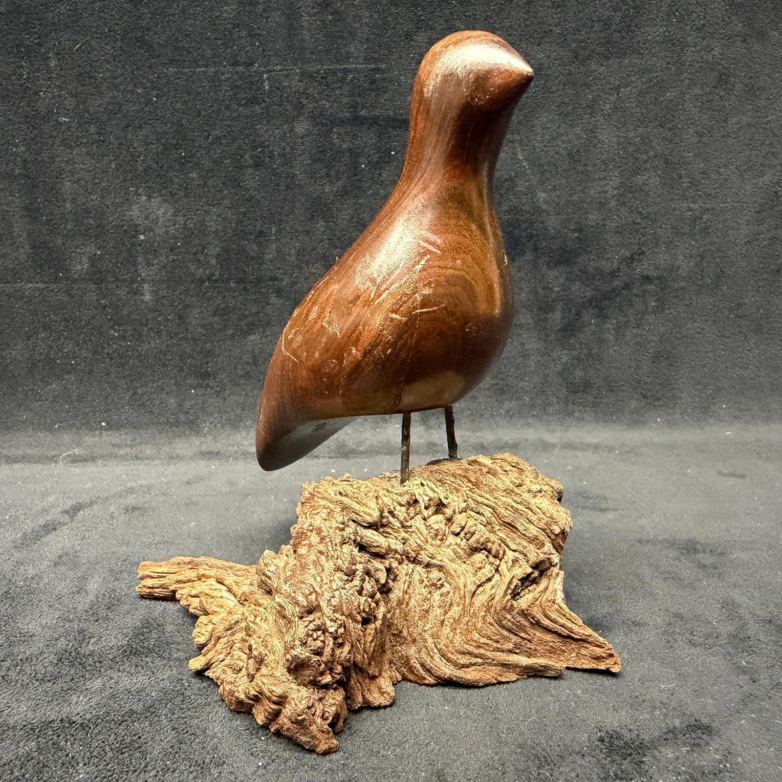Signed Hand-Carved Wood Bird Sculpture on Natural Base: Decorative hand-carved wooden bird sculpture mounted on metal legs over a natural burl/root wood base. Signed on the base, unknown artist. Rich dark wood finish with attractive natural grain and rusti