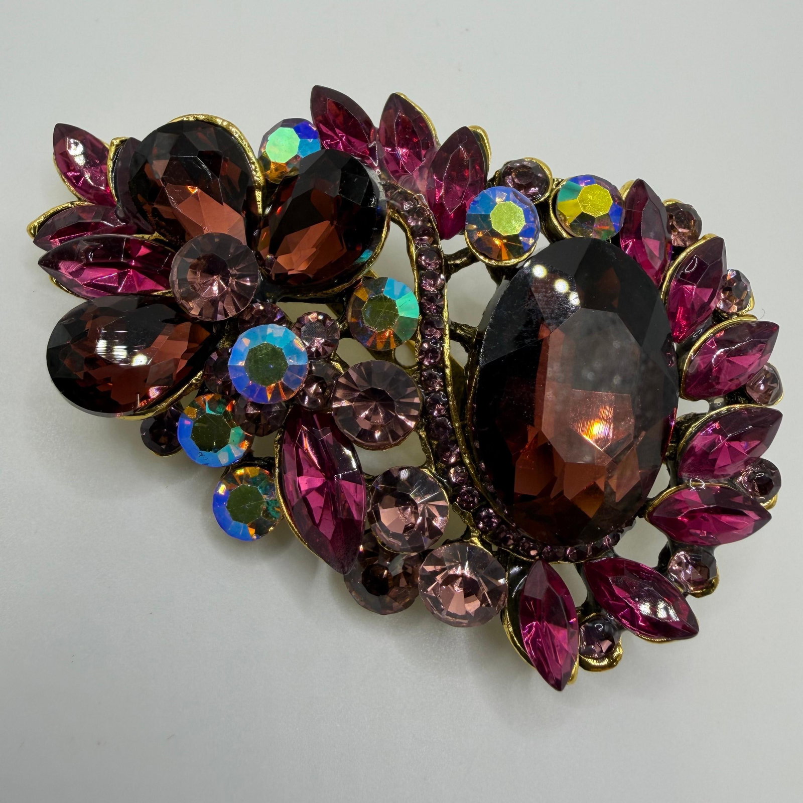 Cluster Purple Rhinestone Costume Jewelry Brooch Unmarked: Unmarked brooch with purple rhinestones in a gold-tone bezel frame. This item is in pre-owned, previously used/displayed condition with noticeable light wear and surface scratches. Please reference al