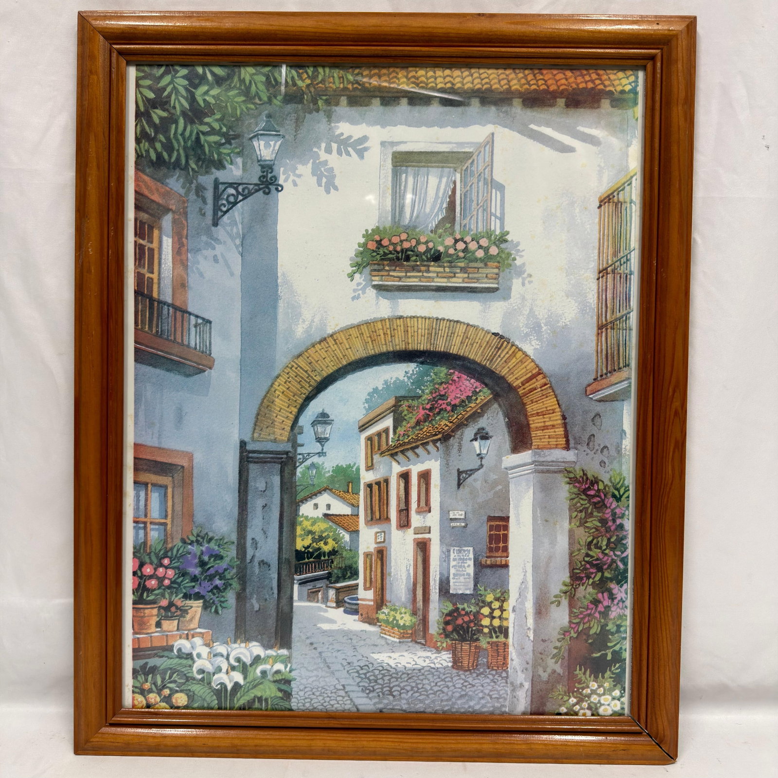 Wall Art Print Framed Mediterranean Alleyway Scene: This is a framed wall art print depicting a Mediterranean alleyway scene. Unsigned; artist and exact origin unknown. This item is in pre-owned, previously displayed condition with light wear and surfa