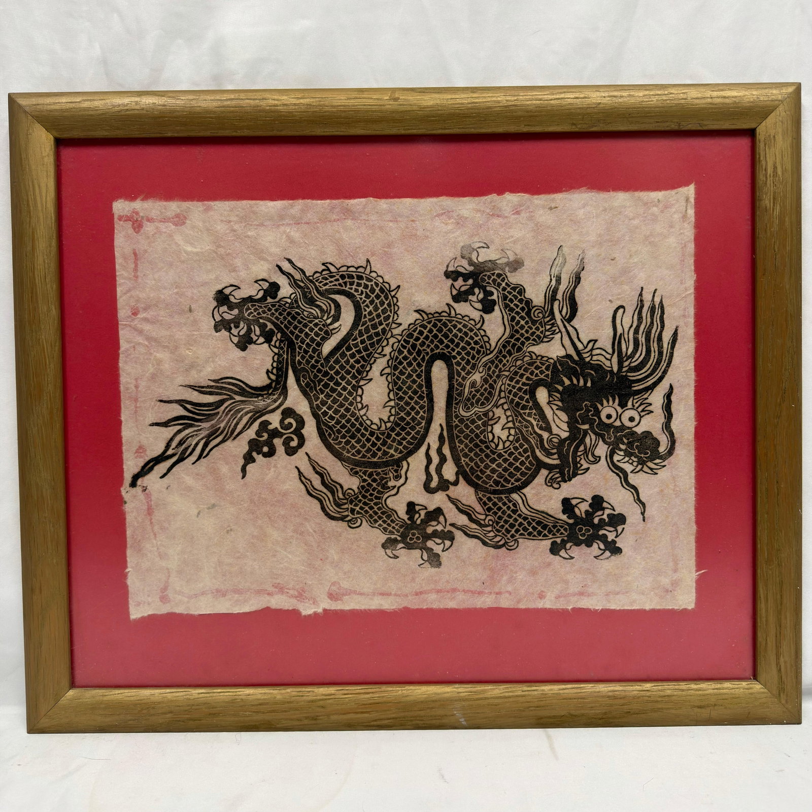 Framed Asian Dragon Print on Decorative Woven Paper: Decorative Asian-style black ink print depicting a traditional five-clawed dragon among cloud motifs. Printed on textured handmade fibrous woven paper with deckle edges and a faint red decorative bord