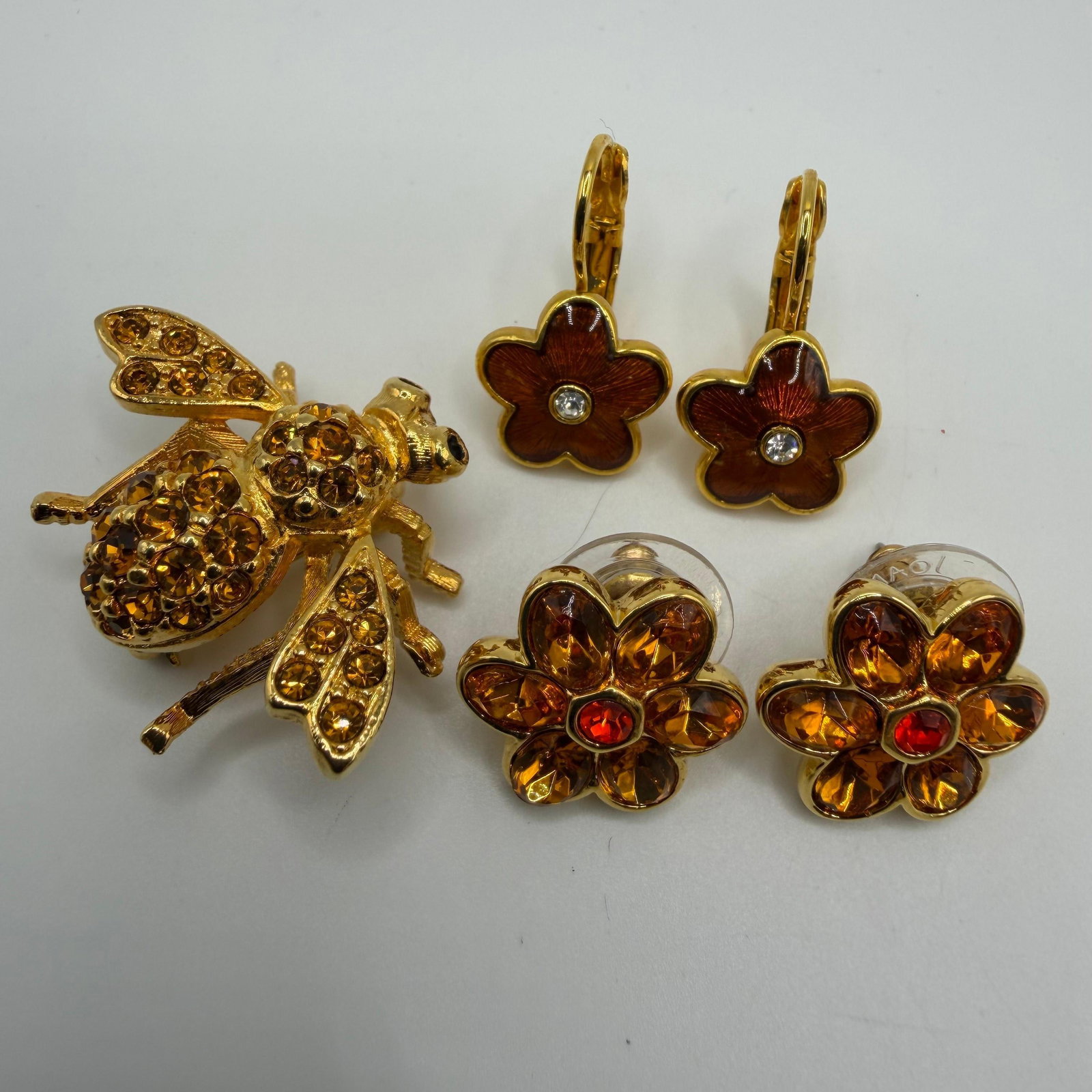 Joan Rivers Amber Crystal Bee and Floral Jewelry Group HH33: Warm amber-toned Joan Rivers jewelry lot featuring a crystal-studded bee brooch, amber crystal flower stud earrings, and brown enamel flower drop earrings with clear crystal centers. Coordinated flora
