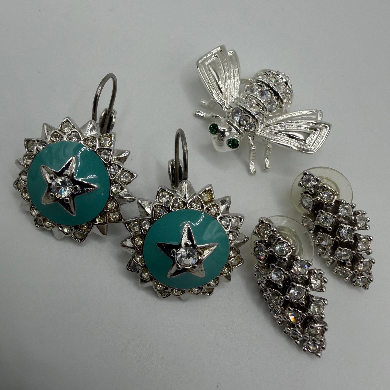 Joan Rivers Enamel and Crystal Jewelry Group HH31: Joan Rivers jewelry assortment features turquoise enamel sunburst drop earrings, a clear crystal bee brooch with green stone eyes, and a pair of clear crystal cluster earrings. A bright