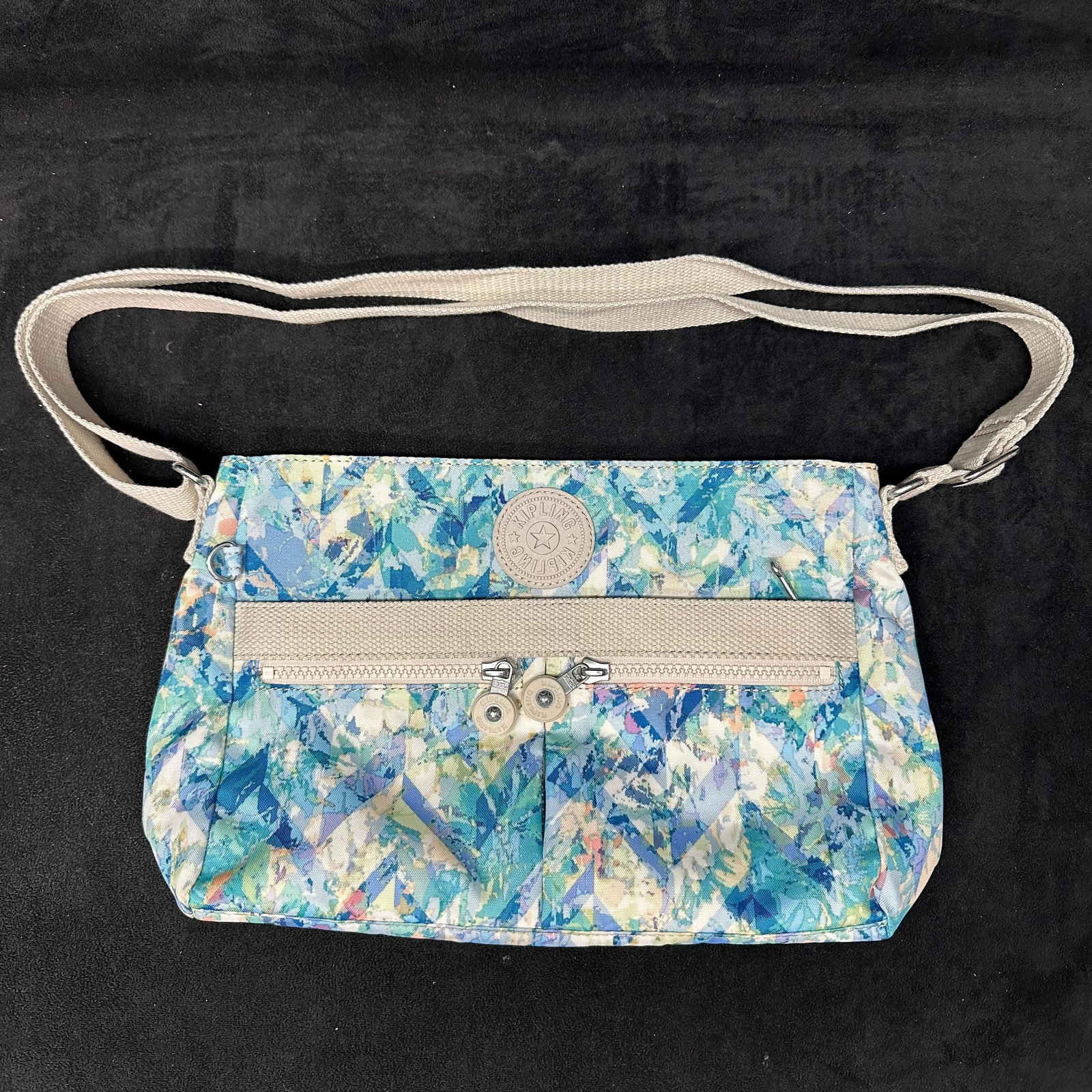 Kipling Angie Nylon Crossbody Shoulder Bag Blue Green White: Kipling nylon crossbody shoulder bag featuring a multicolor abstract pattern. Includes an adjustable fabric shoulder strap, zip-top closure, exterior zip pocket, and interior zip pocket with light-col