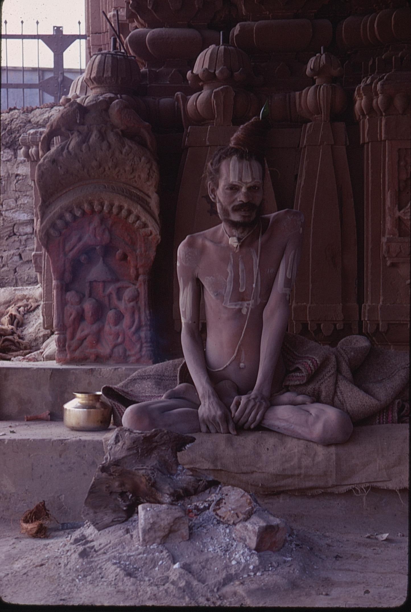 35mm Kodachrome Photo Slide and Digital Prints Sadhu Ascetic Seated by Temple Shrine India: 35mm Kodachrome photograph slide and digital prints depicting a Sadhu (Hindu ascetic) seated in meditation near a temple shrine. The figure is adorned with traditional ash markings and sits cross-legg