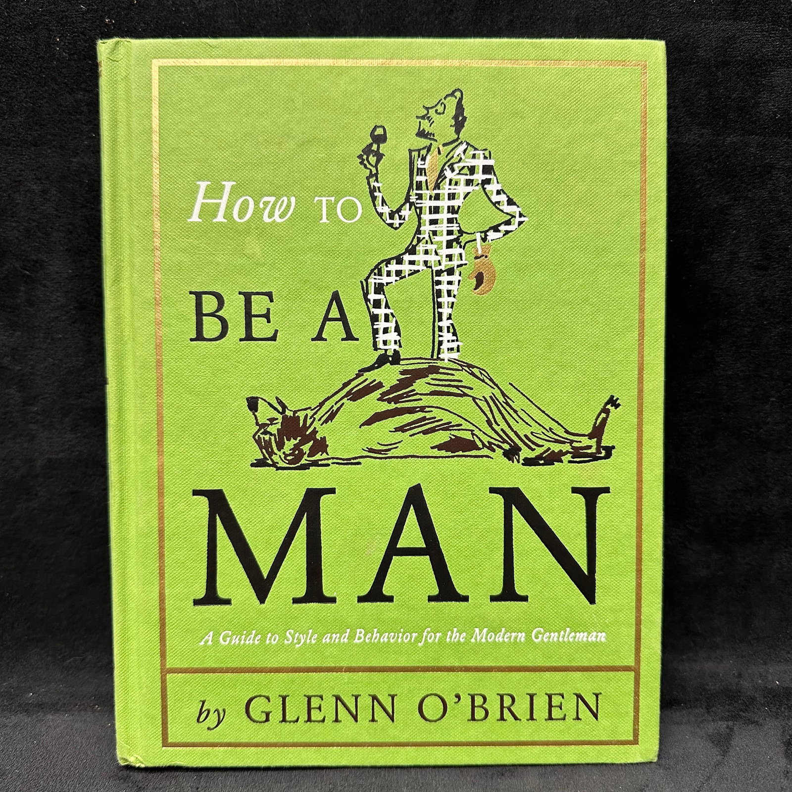 How To Be A Man Signed by Glenn O'Brien Hardcover Book: Signed with a personal inscription to Michel Roux. Condition shows general handling wear, scuffing, and surface marks to the cover consistent with age. Interior pages appear intact. This item is in
