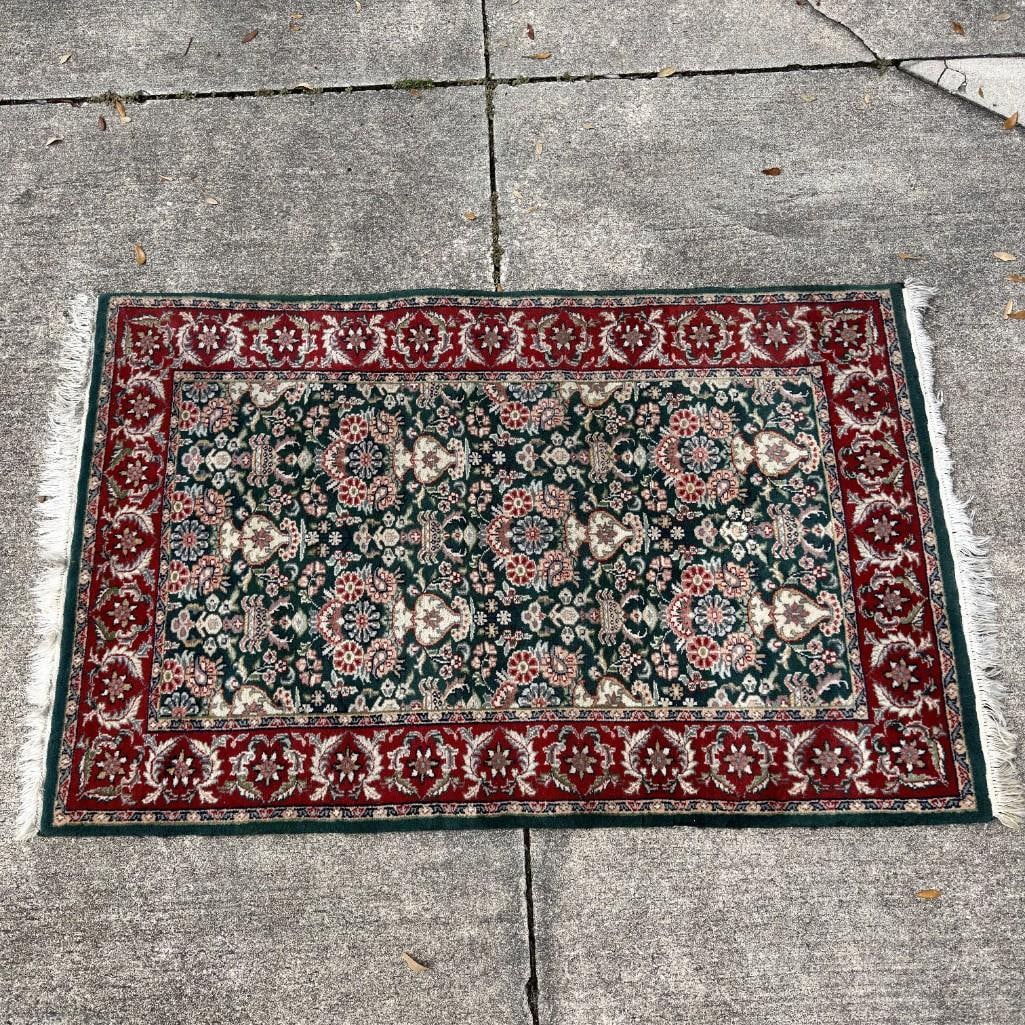 Vintage Oriental Style Floral Accent Rug with Fringe: Vintage Oriental-style accent rug featuring an allover floral pattern with a deep green field and red floral border. Finished with fringe at both ends. Unmarked. Note there is a small area of edge wea