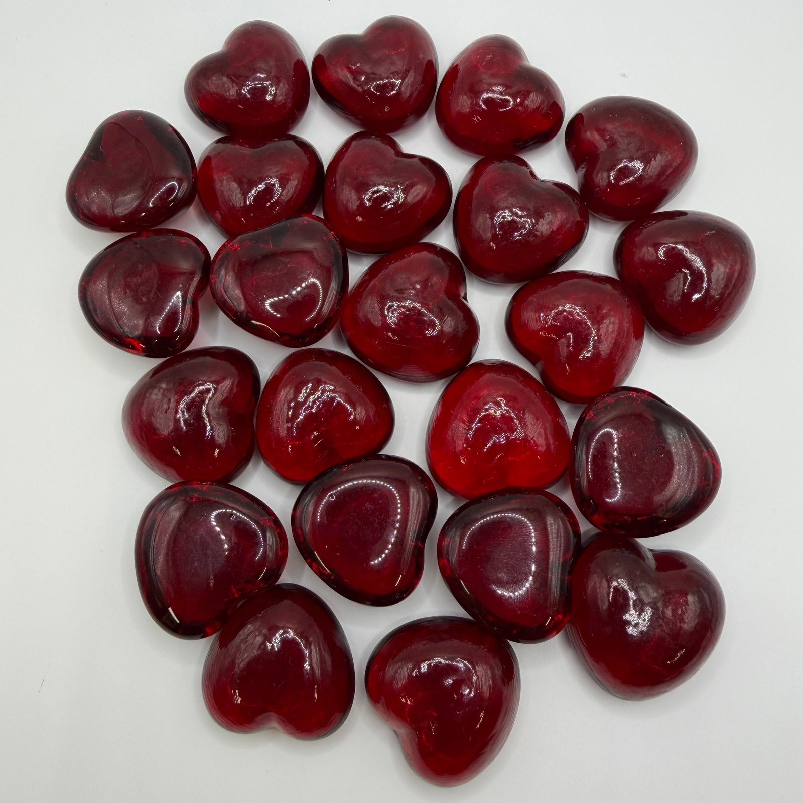 Lot of 23 Red Heart Shaped Art Glass Pieces Paperweights Ruby Red: Collection of twenty (23) solid red heart-shaped art glass paperweights or decorative display pieces. Each features a translucent ruby red color with a polished finish. These items are in pre-owned, p