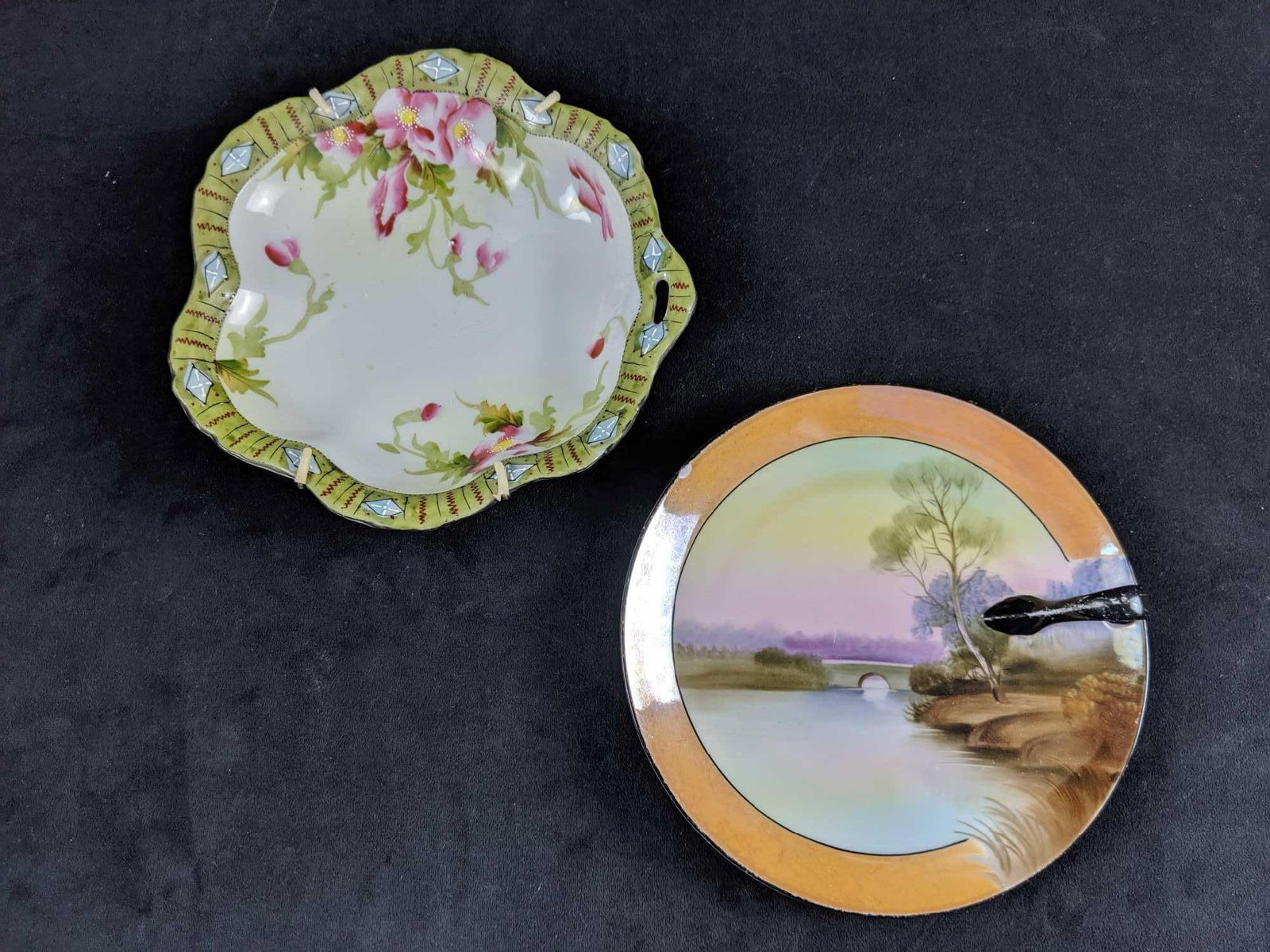 Set Of Two Hand Painted Antique Porcelain Plates: This set includes an Noritake porcelain plate with a finger handle. This is hand painted and from Japan. Measures 7" across. There is a small chip (see image) along with an even smaller scratch. 