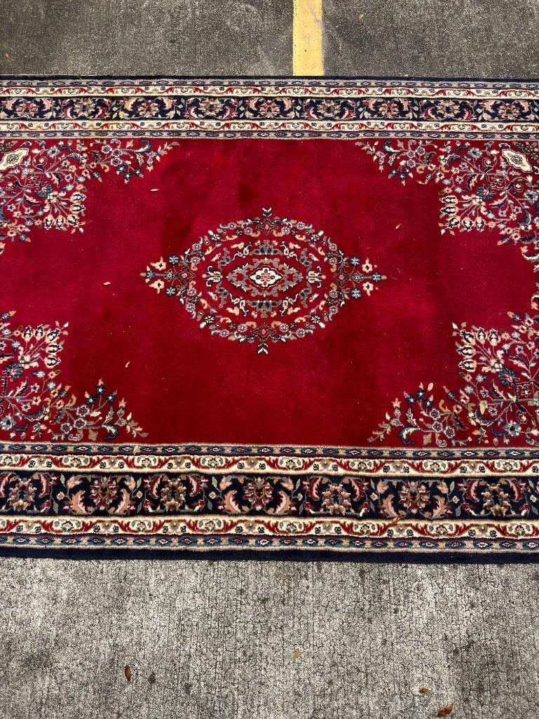 Large Red and Navy Blue Traditional Oriental Style Area Rug with Medallion Design: Traditional Oriental-style area rug featuring a rich red field with a central medallion and navy floral border. Finished with fringe on both ends. Displays expected wear from use, including areas of p