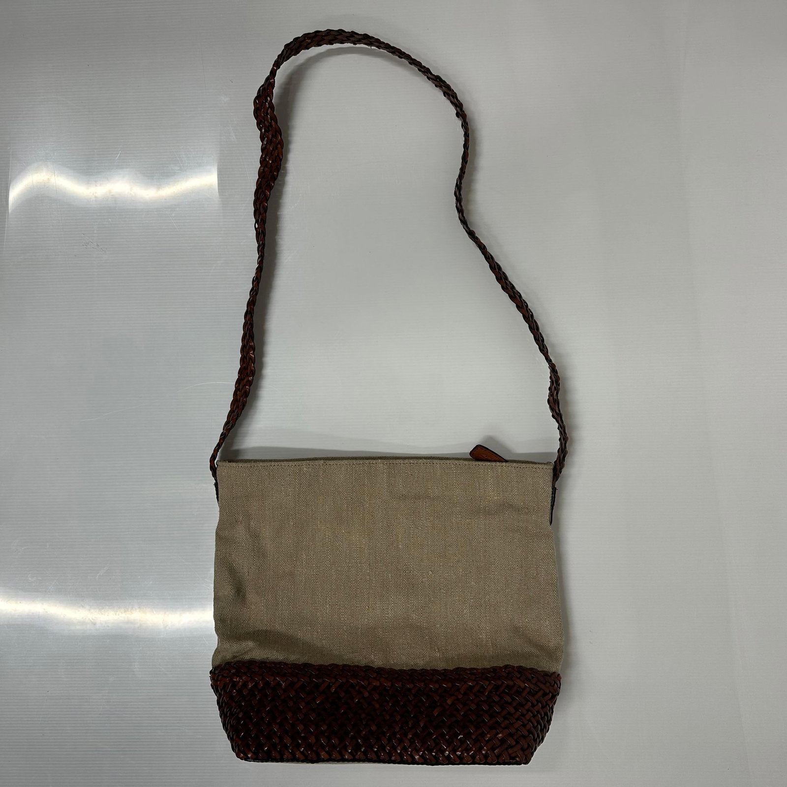 Talbots Woven Leather and Canvas Shoulder Bag with Braided Strap: Talbots shoulder bag features a beige canvas upper body and a dark brown woven leather lower section. Braided leather shoulder strap. Solid leather bottom panel. Top zipper closure. Includes interior 