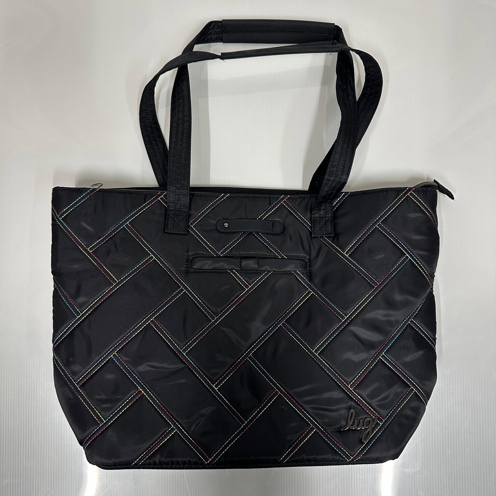 Lug Skyliner Black Quilted Tote Bag with Rainbow Stitching: Lug Skyliner tote bag in black nylon with multicolor rainbow contrast stitching in a quilted geometric pattern. Double top handles with padded grip. Zip top closure. Front exterior slip pocket. Interi