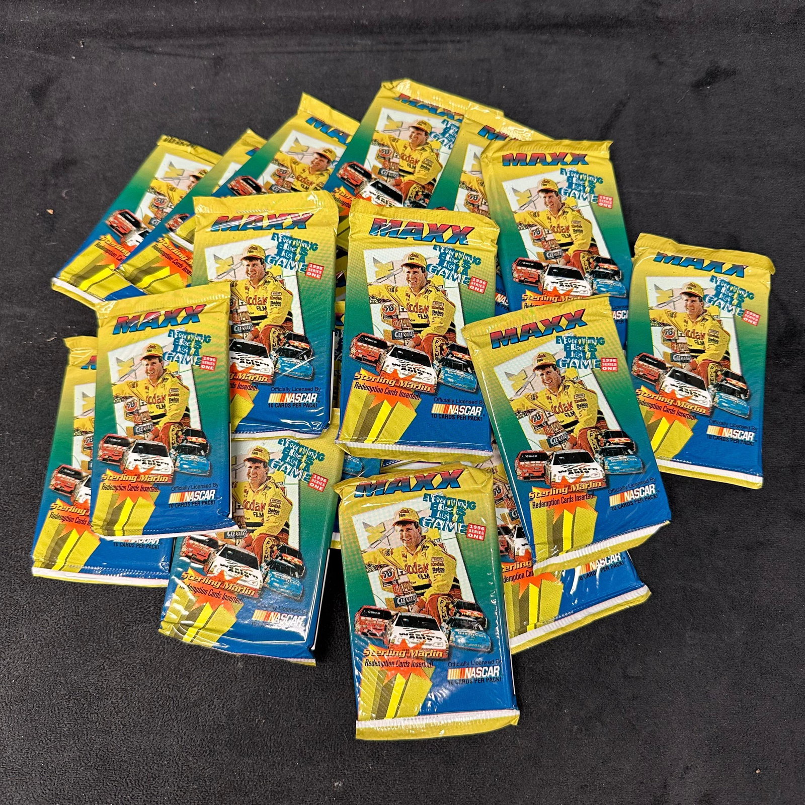 Lot of 22 Sealed 1996 Maxx NASCAR Series One Trading Card Packs: A lot of 22 factory sealed 1996 Maxx NASCAR Series One trading card packs. Each pack contains 10 cards per pack and is officially licensed by NASCAR. Front of packs feature Sterling Marlin in Kodak