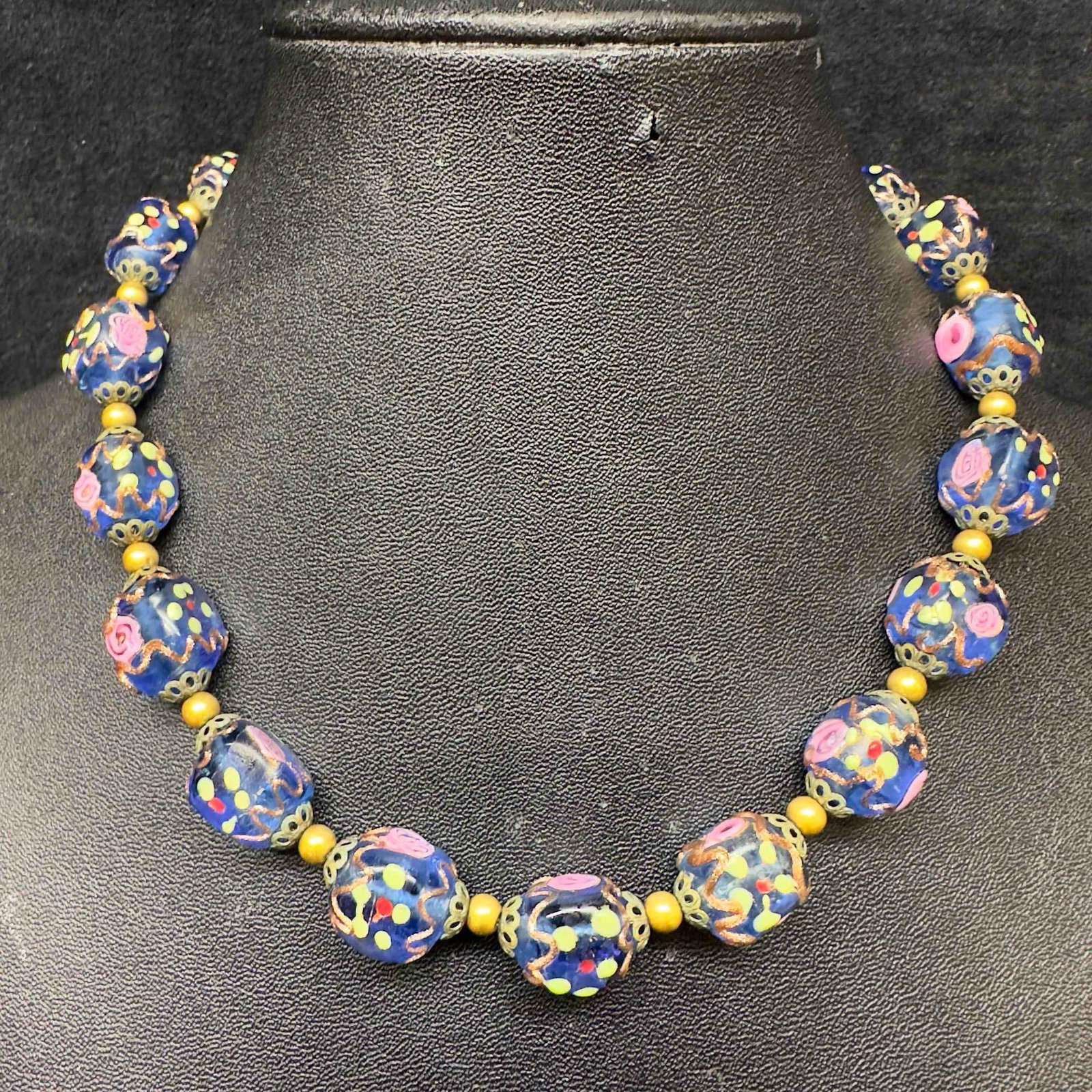 Venetian Murano Art Glass Lamp Work Dark Blue Floral Pink Beaded Necklace E13: Venetian Murano Art Glass Lamp Work Dark Blue Floral Pink Beaded Necklace E13. Necklace with blue colored glass beads with beautiful hand painted designs on each. The necklace features pink colored fl