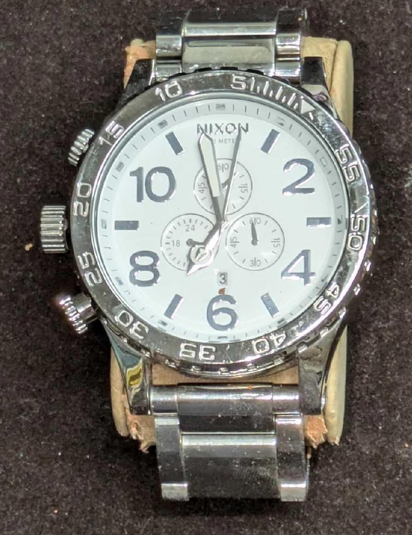 Men's Nixon 51-30 Chronograph - Chrome & White Wristwatch: Men's Nixon 51-30 Chronograph - Chrome & White Wristwatch. The watch requires a new battery and has not been tested. Please note, the watch does not come with the holder seen in the image