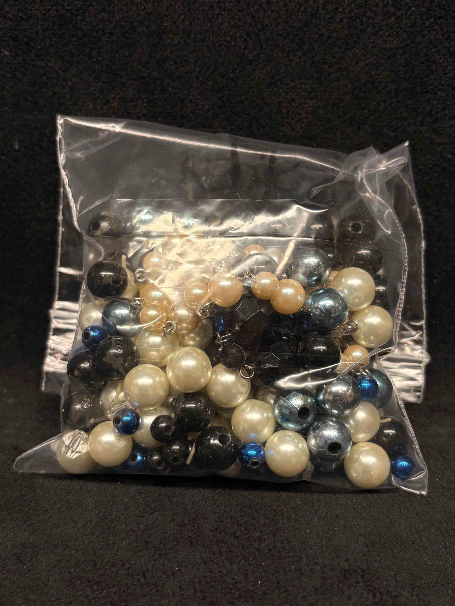 4.5 OZ of Black Pearlescent and Blue Loose Beads: This lot contains loose and/or broken pieces of costume jewelry, charms, buttons, beads, etc. All of which in overall good condition for crafting with minor surface scuffs and scratches due to age