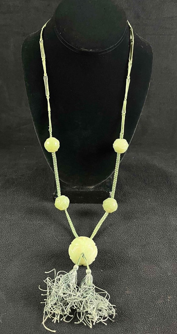 Jade Carved Bead Necklace: Jade Carved Bead Necklace Pictured is a beautiful necklace with large jade beads with carved designs. The necklace is also made up of skillfully weaved string the beads are weaved onto. This necklace 
