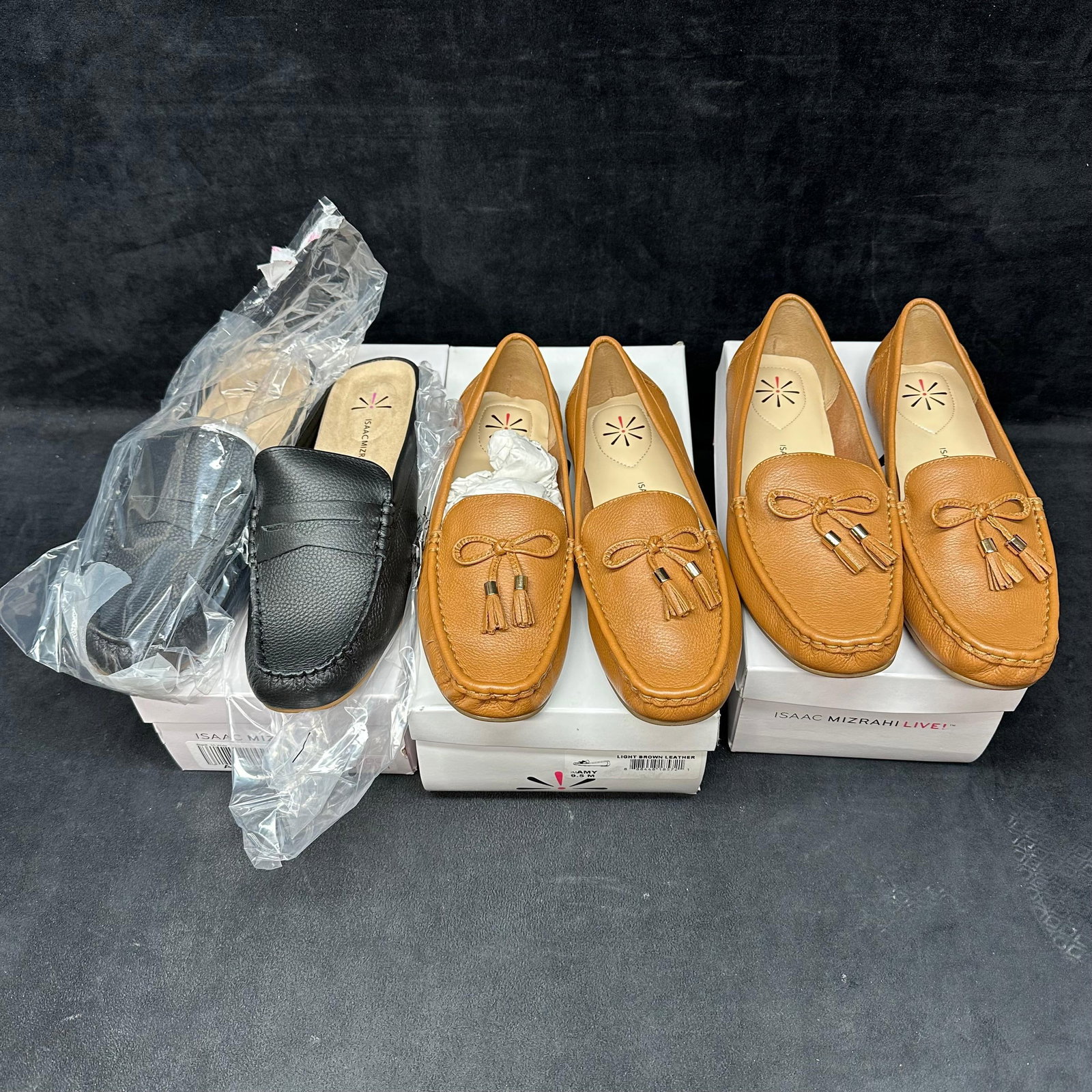 Isaac Mizrahi Live Womens Leather Loafer Shoes Lot of Three: Set of three pairs of Isaac Mizrahi Live women’s loafers, all appearing new in boxes. Includes one pair in black leather, wide width, and two pairs in light brown leather, each featuring tassel 