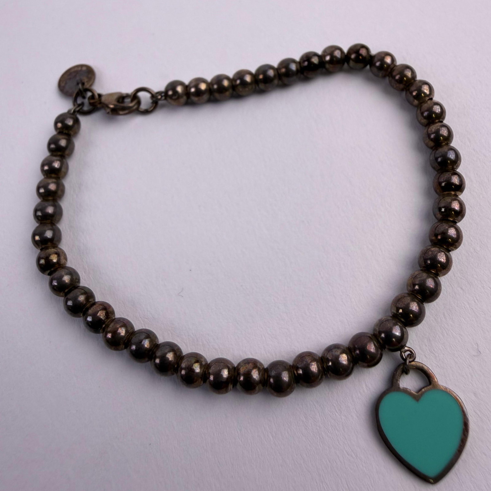 Tiffany and Co Sterling Silver Enamel Mini Heart Tag Charm Bead Ball Bracelet AG925: This item is in good pre-owned, previously used/displayed condition with noticeable light wear and surface scratches. Please reference all photos for full details. This piece of jewelry has been caref