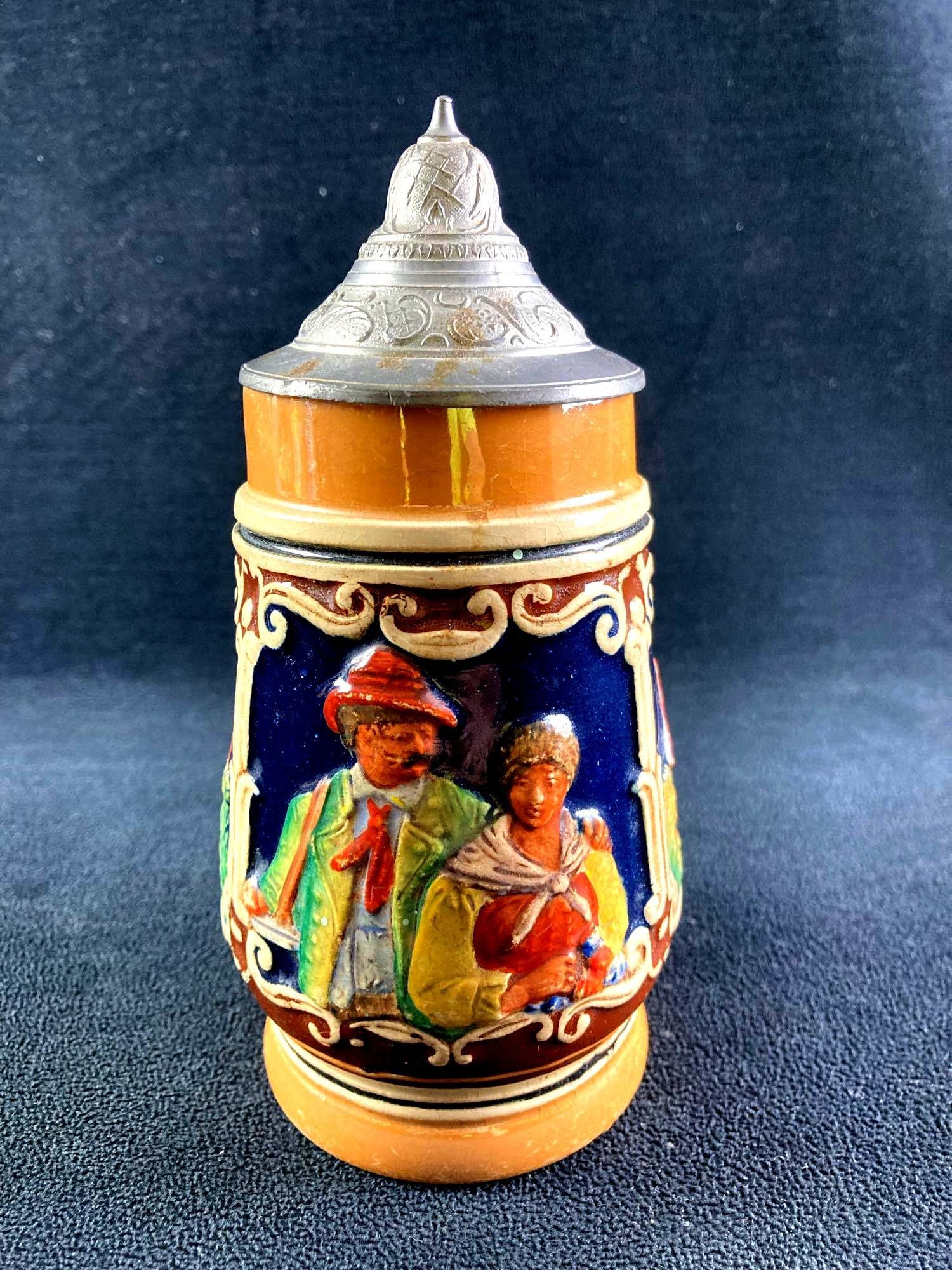 Small German Beer Stein: This lot includes: (1) Small German Beer Stein Condition is used and see photographs for additional details. The beer stein lid is intact, but has no apparent manufact